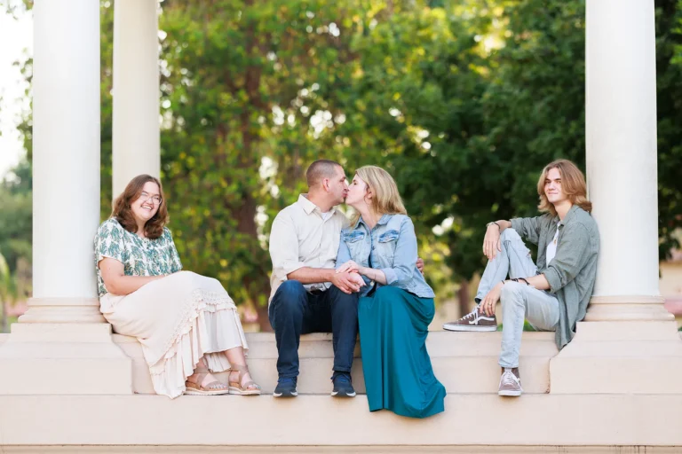 Parents kissing near teenage kids at the Balboa Park Organ Pavilion