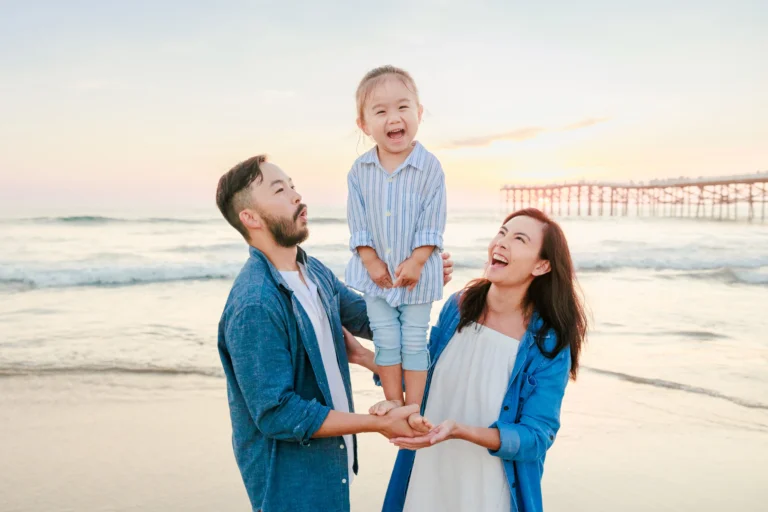 Toddler Balancing on Parents' Hands and Laughing
