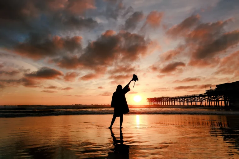 Female Graduation Sunset Beach Silhouette in Cap and Gown