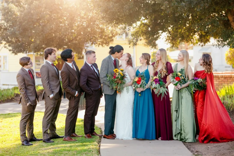 Wedding Party in Jewel Tones Celebrate the Bride and Groom's Kiss
