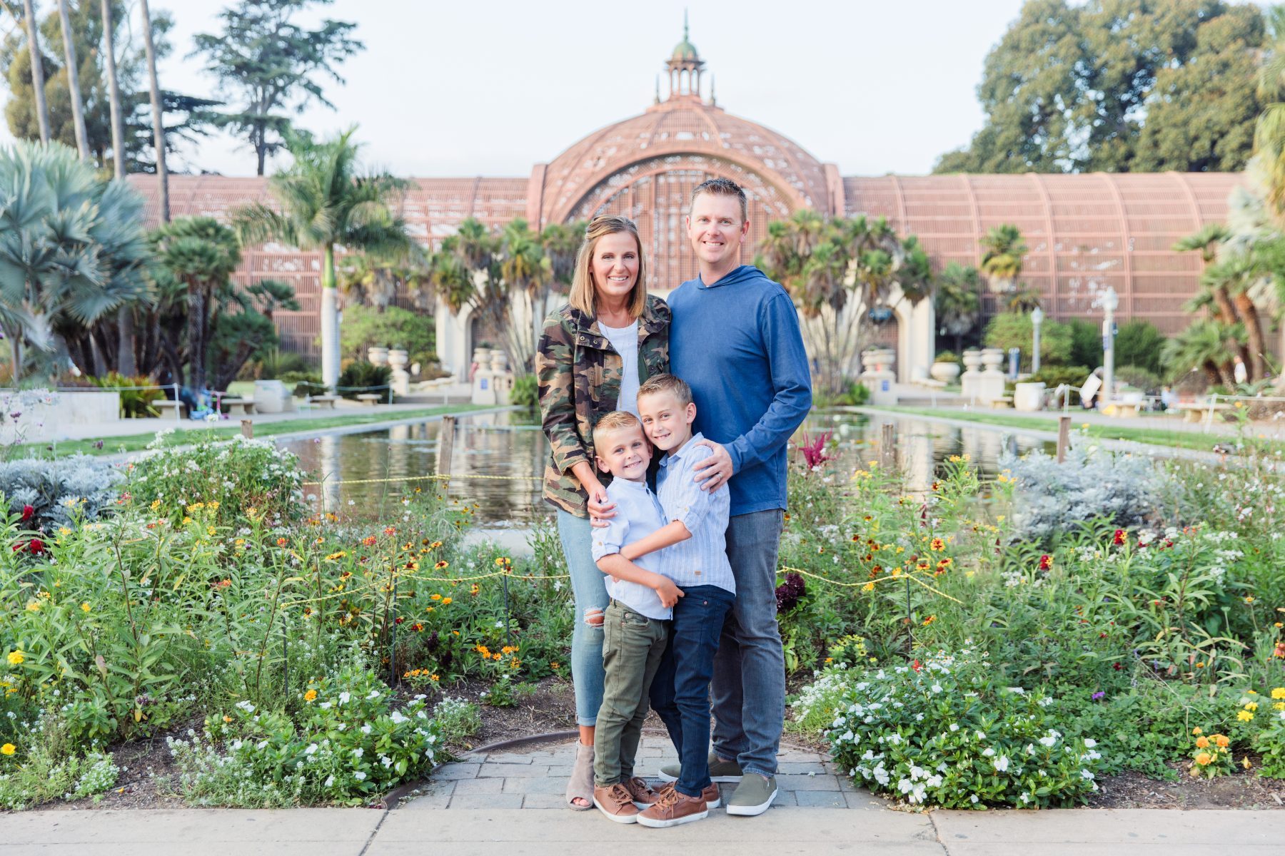 Mom, dad and two sons pose by Balboa Park's Botanical Building pond