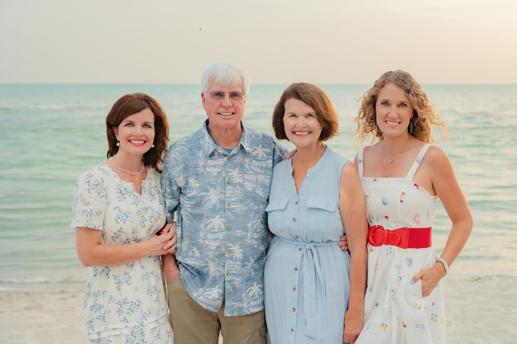 Family of four in blue and white poses on Captiva beach