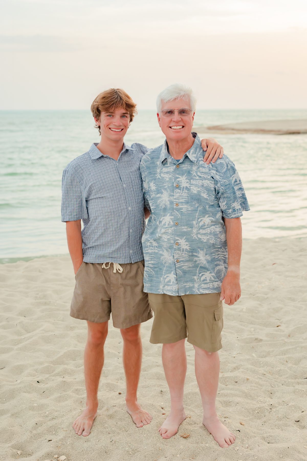 Father and son embrace on Captiva Island beach at sunset