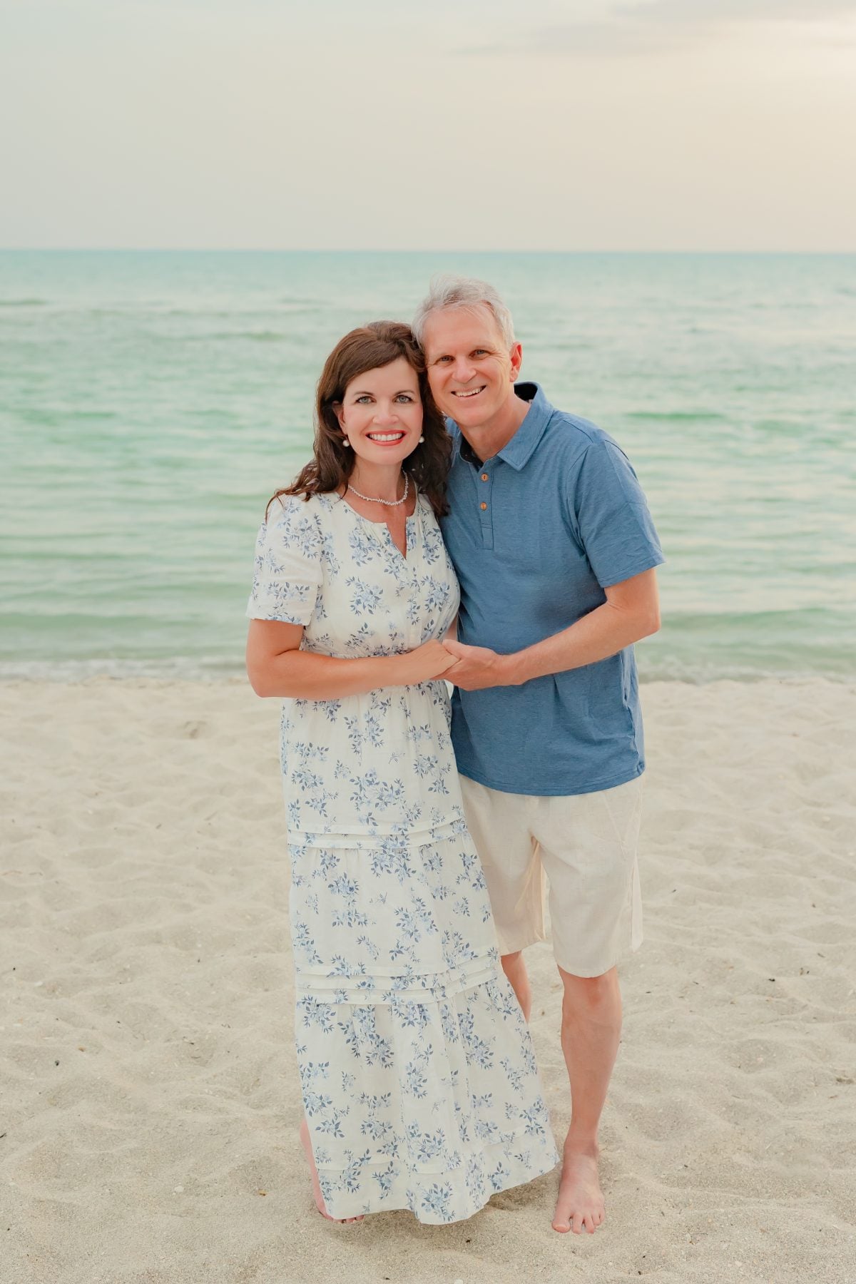 Older couple embraces on the beach at golden hour