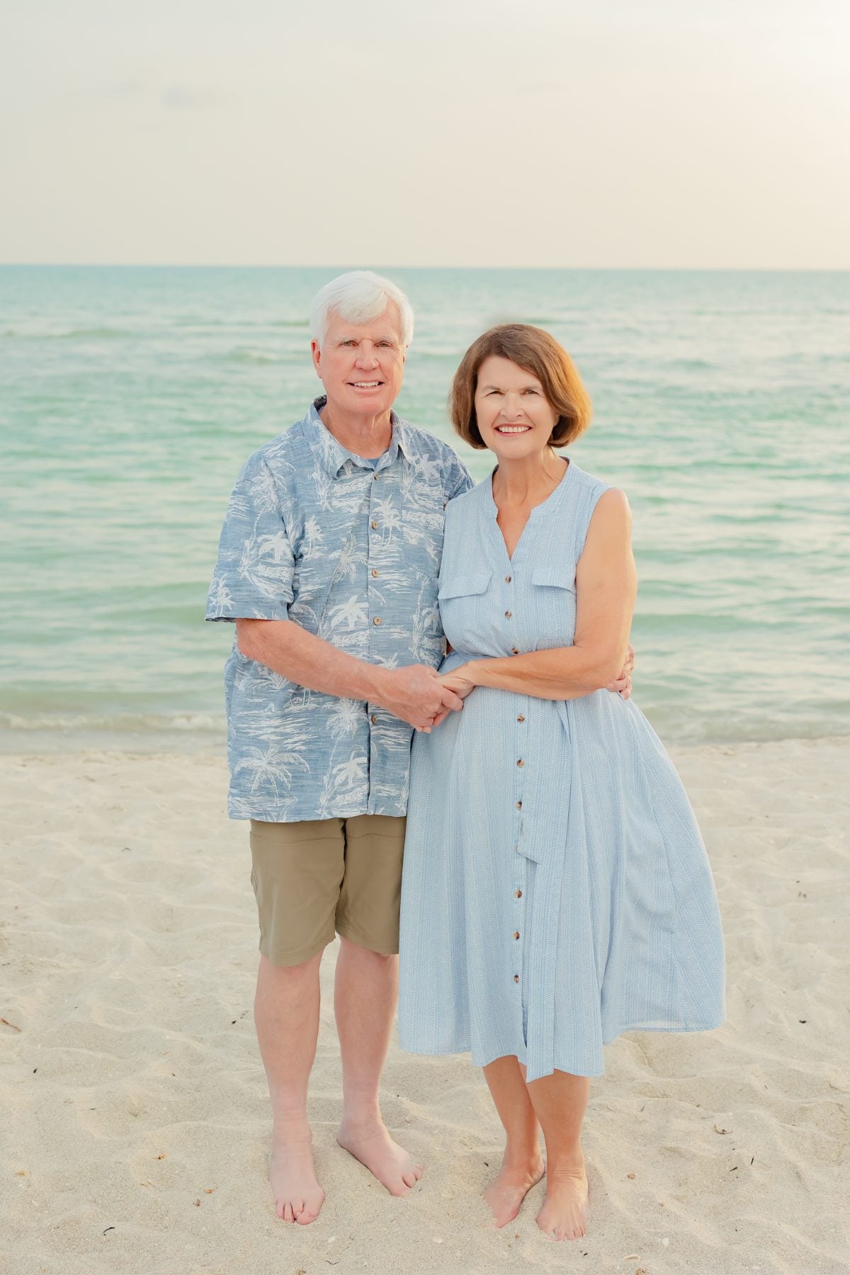 Older couple holds hands smiling on Captiva Island beach