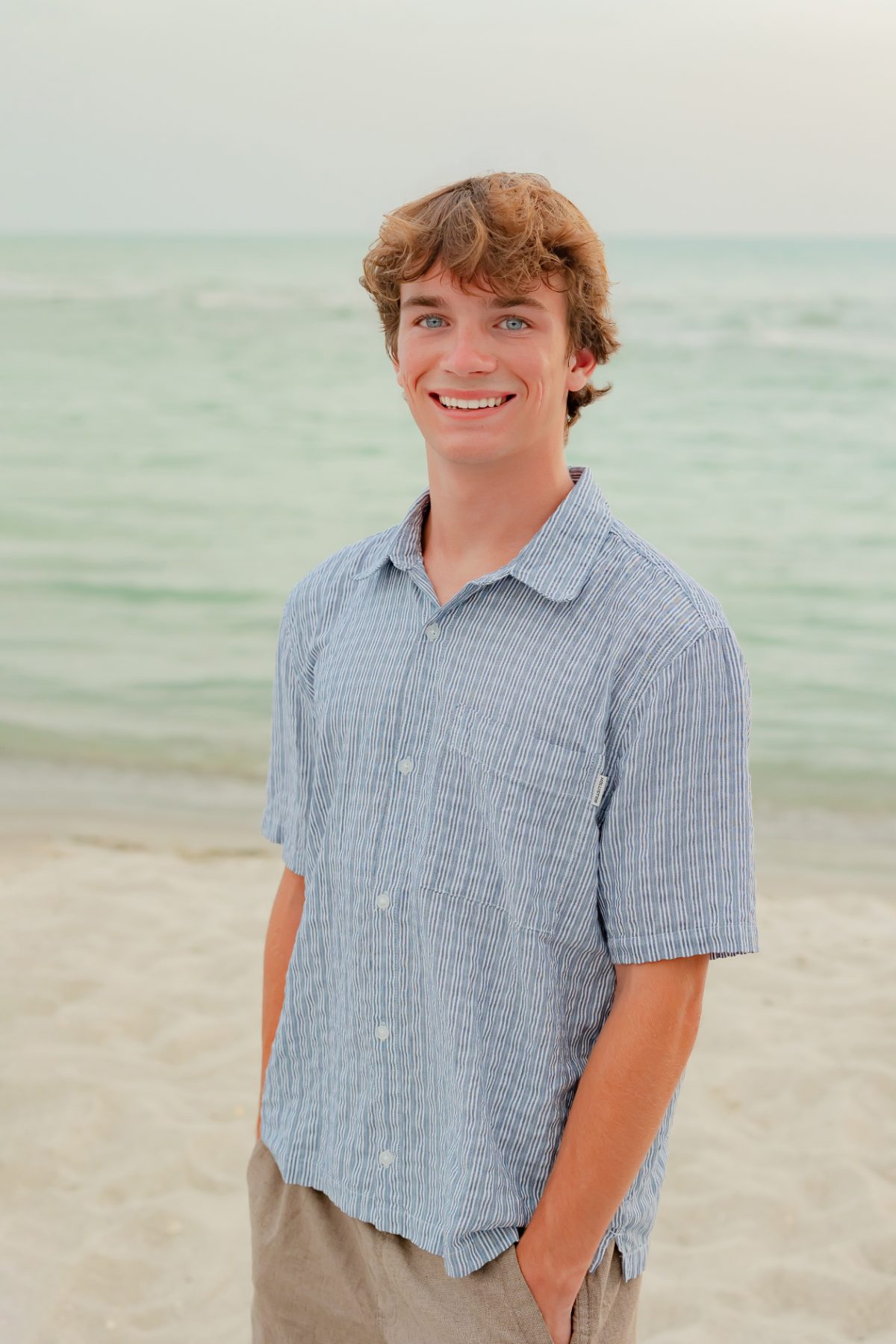 Teen boy in striped shirt smiles on Captiva Island beach