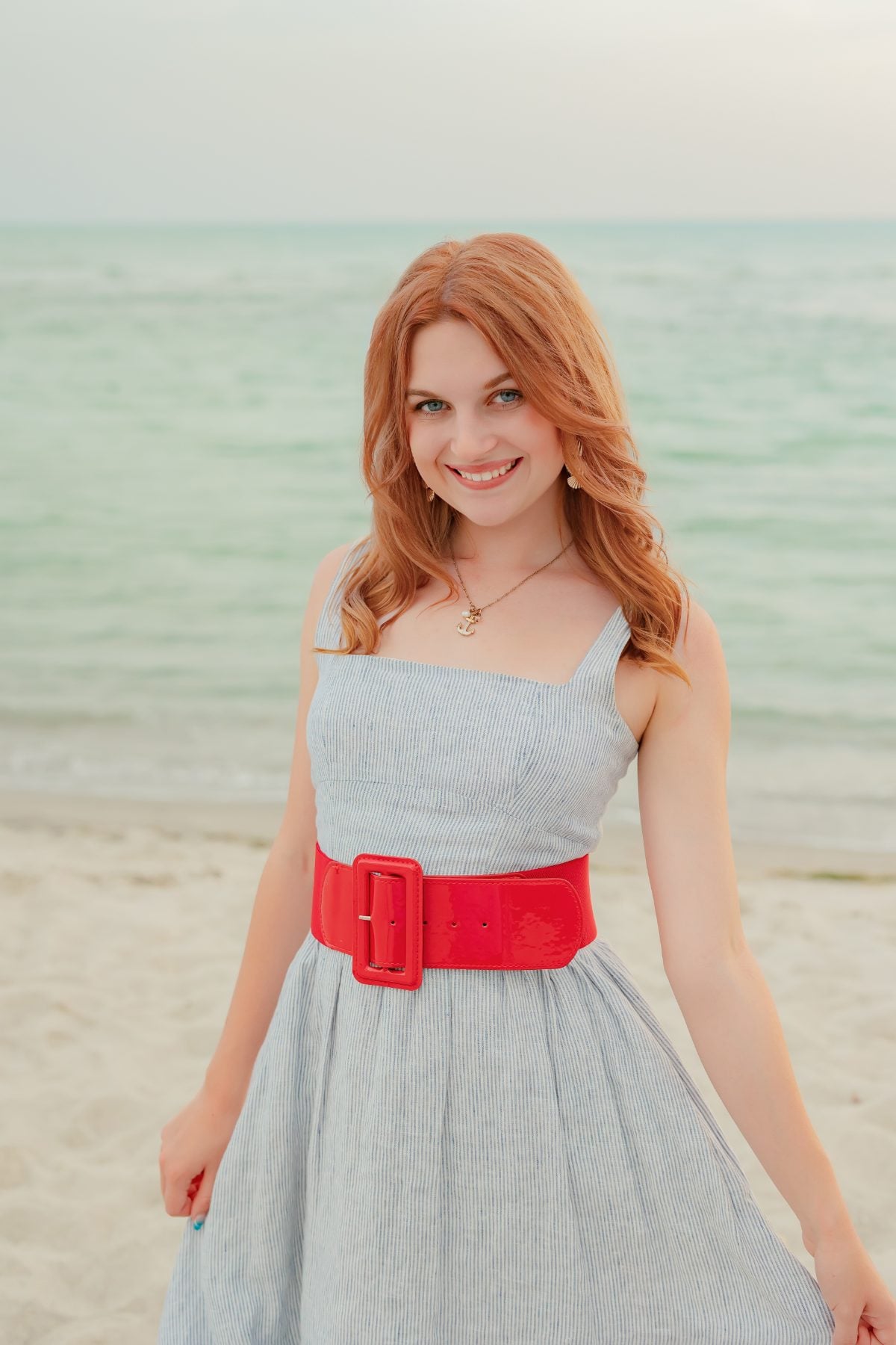 Redhead woman in striped dress smiles on Captiva Island beach