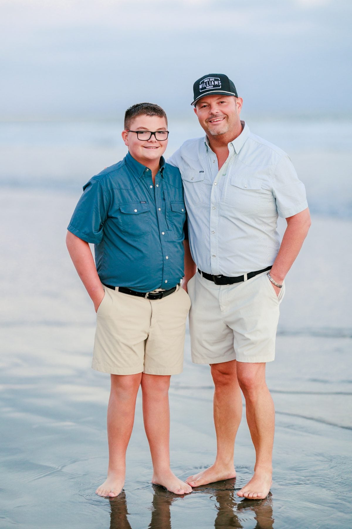 Father and son stand together barefoot on Coronado Beach