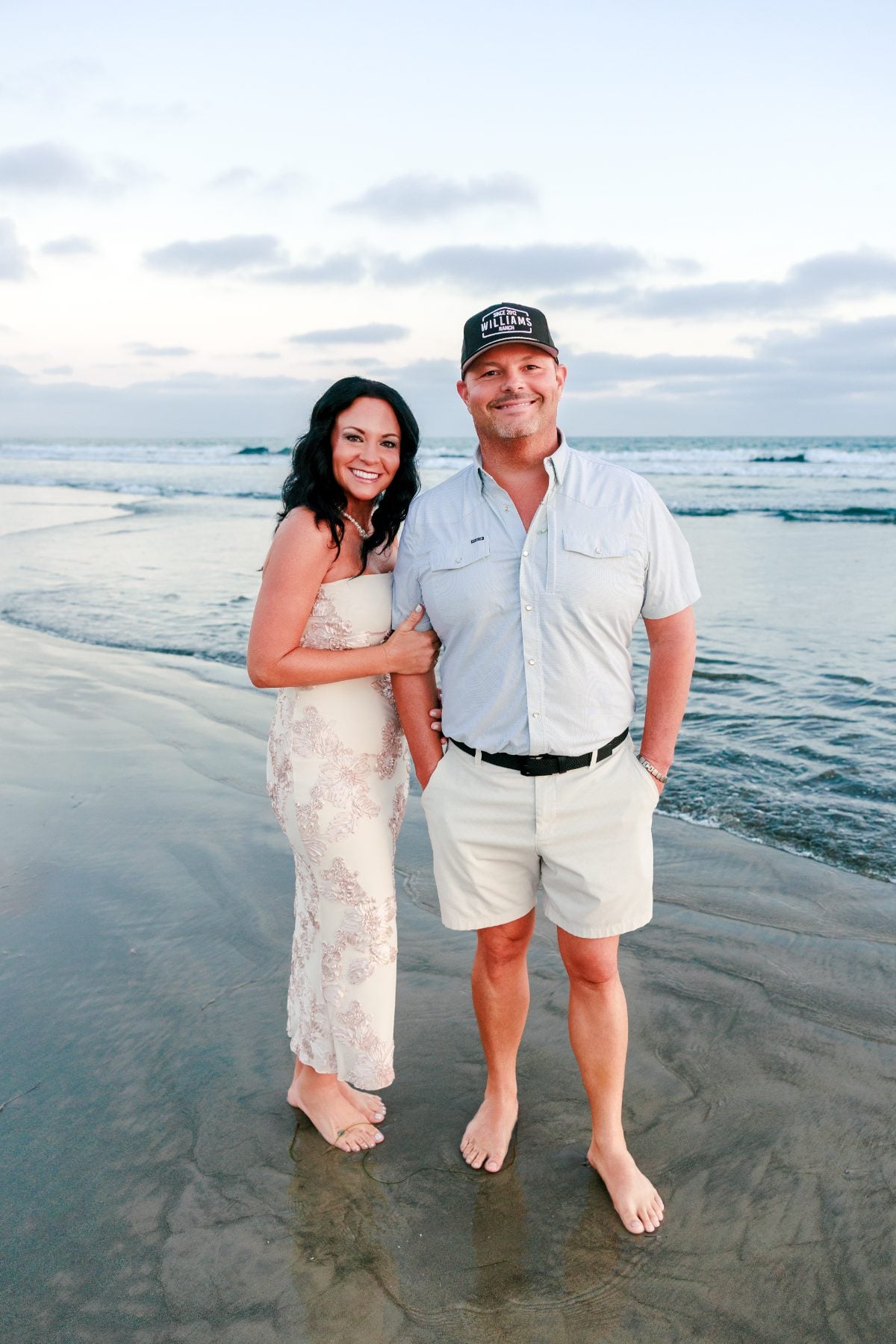 Husband and wife pose barefoot on sand near Hotel del Coronado