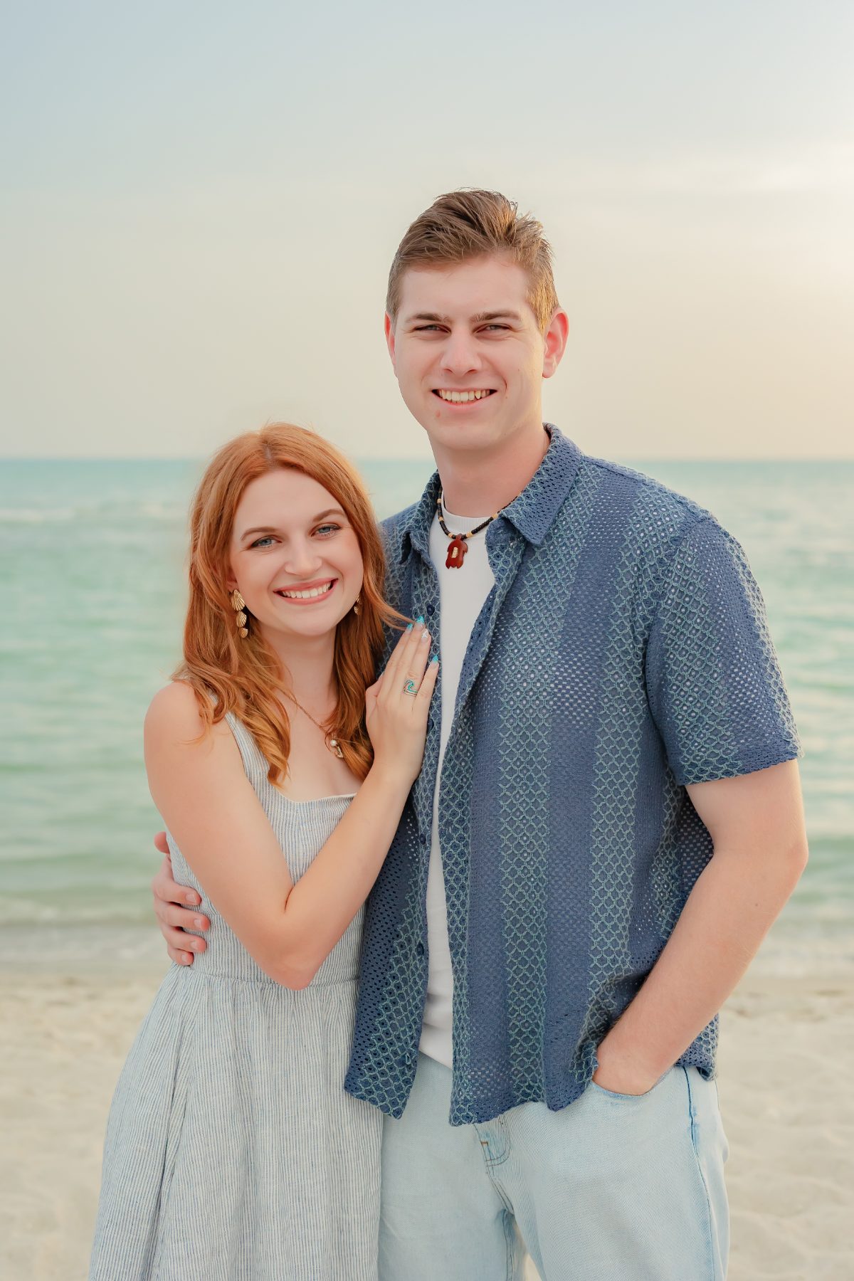 Redheaded woman leans affectionately on boyfriend during Captiva beach photos