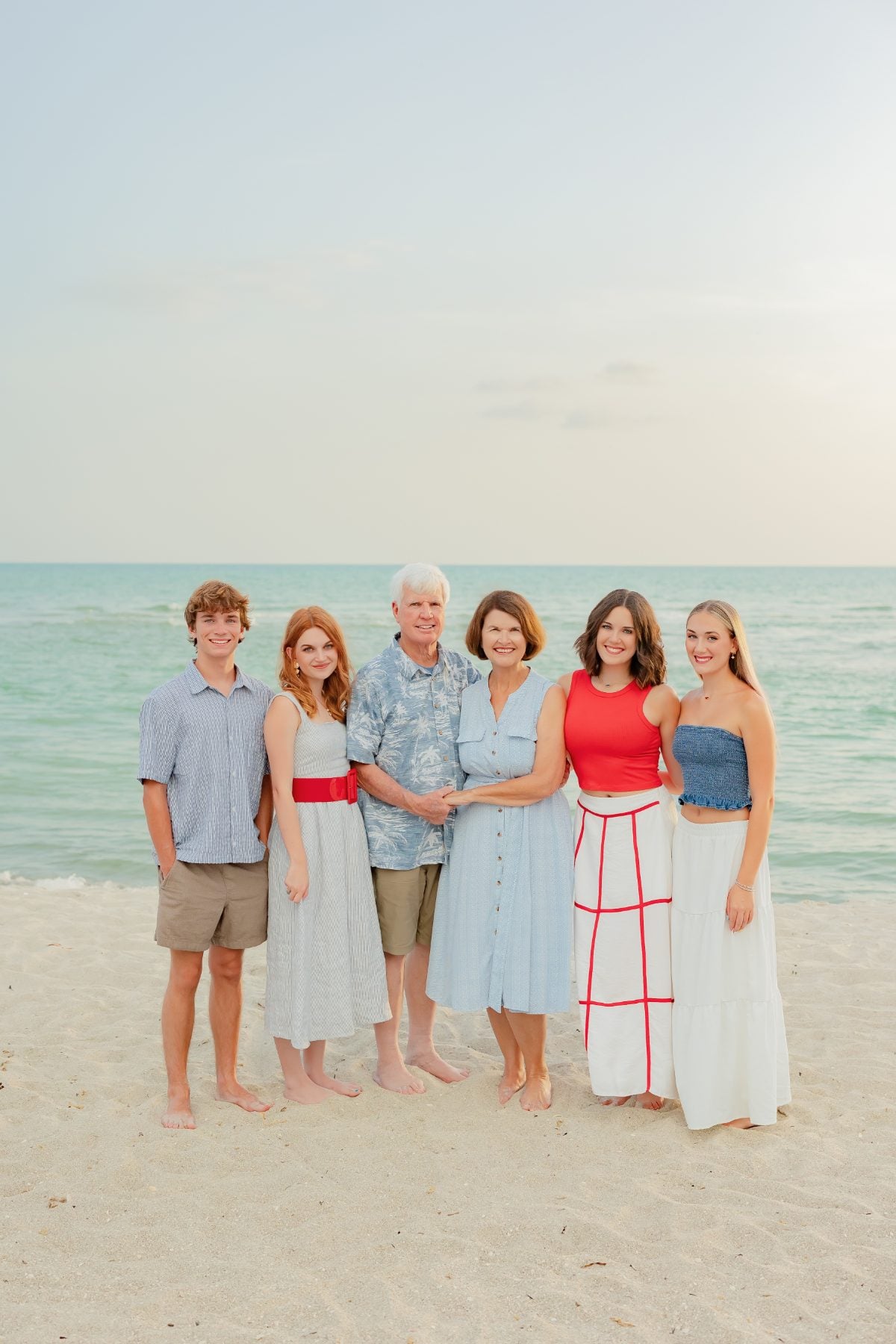 Extended family of six poses together on the sand in Captiva Island