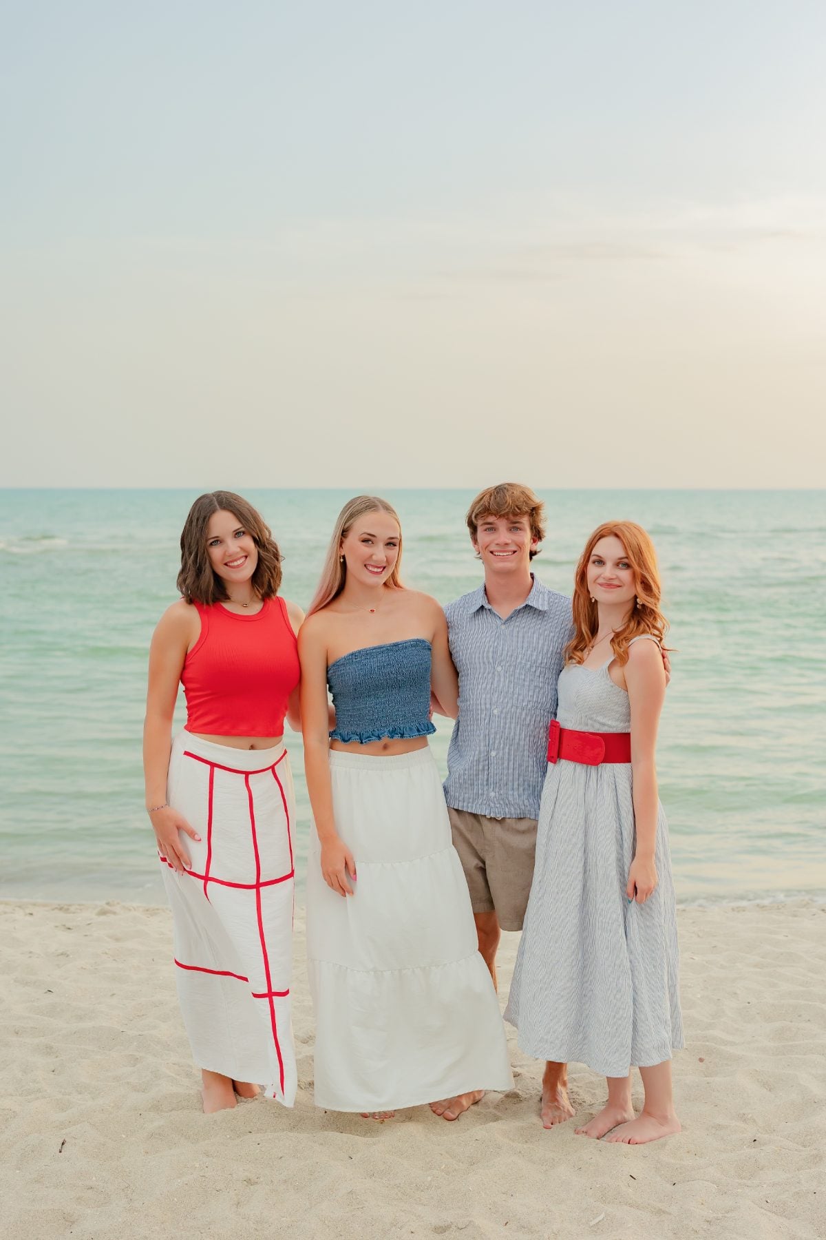 Four siblings standing close together for a Sanibel Island beach portrait