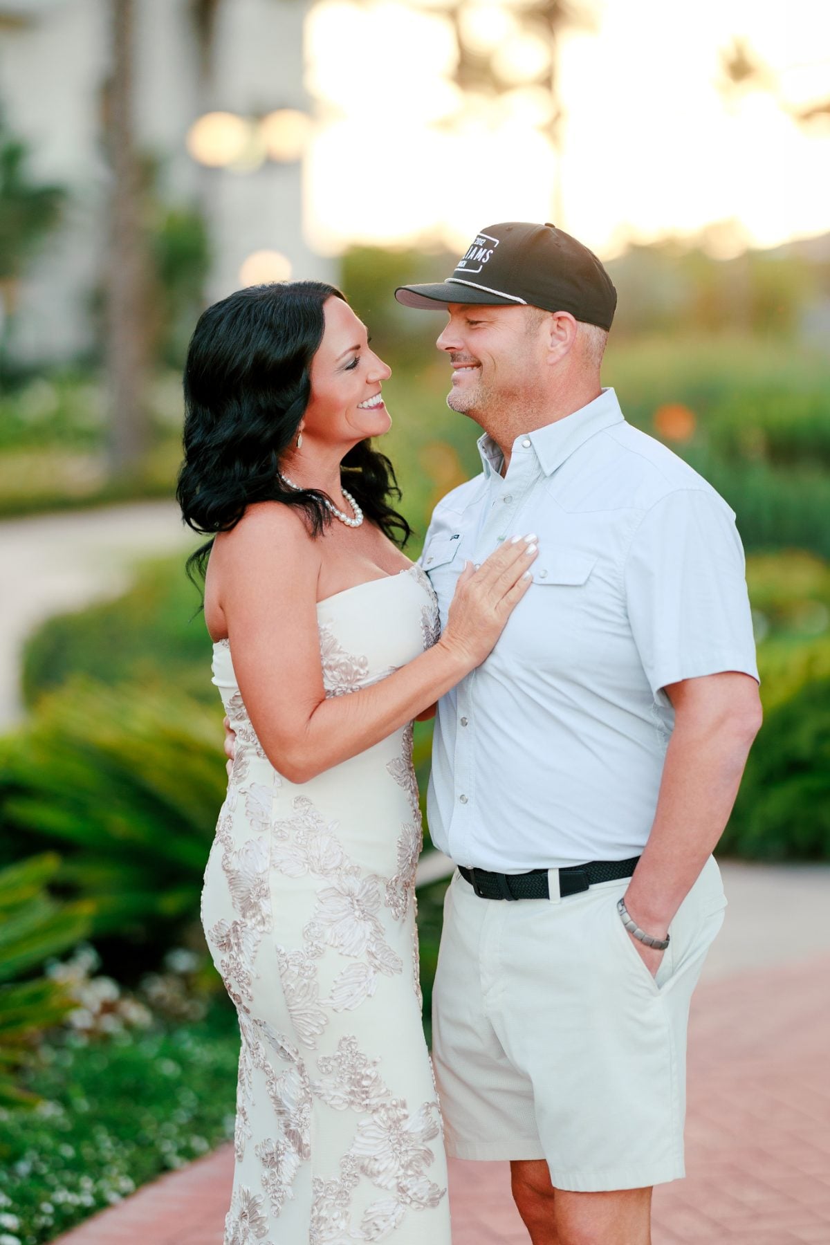 Couple shares a warm embrace in garden pathway at Hotel Del Coronado