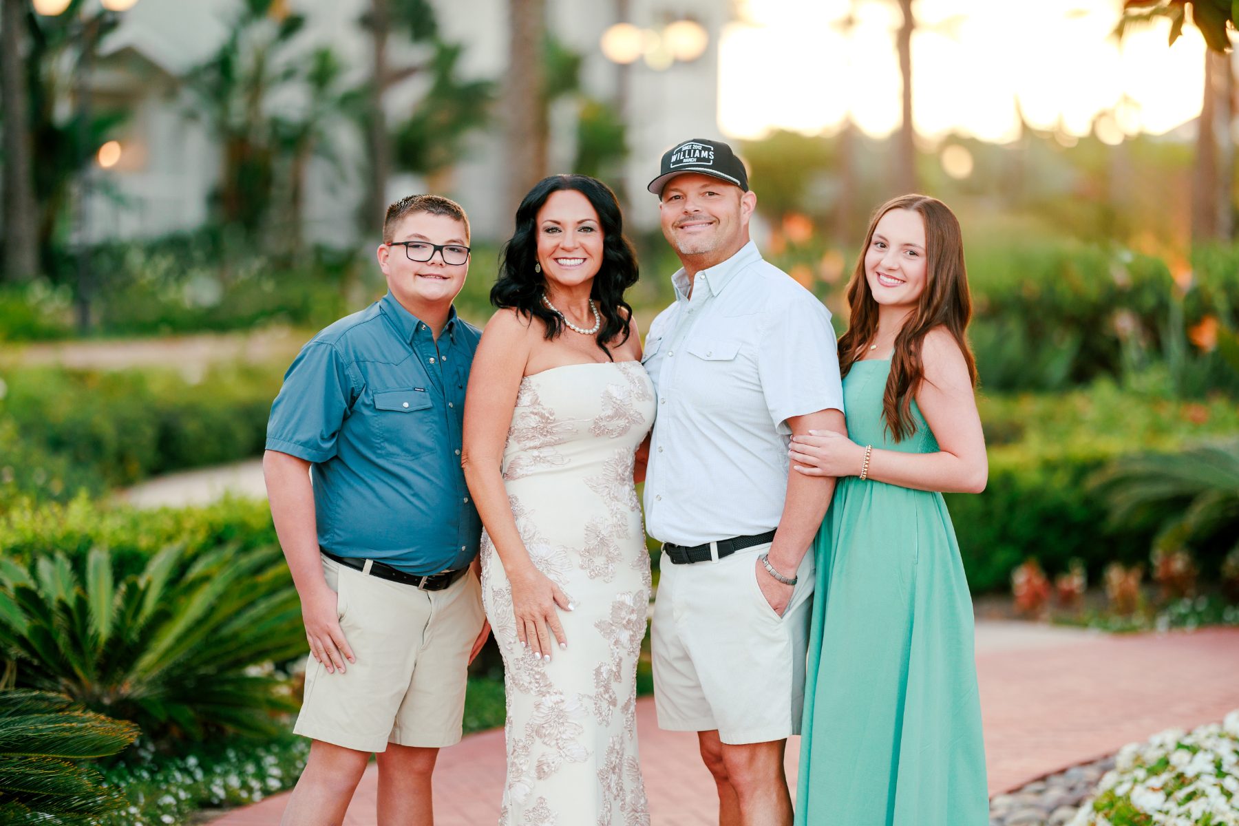 Family of four smiling together at sunset for Hotel del Coronado family photos