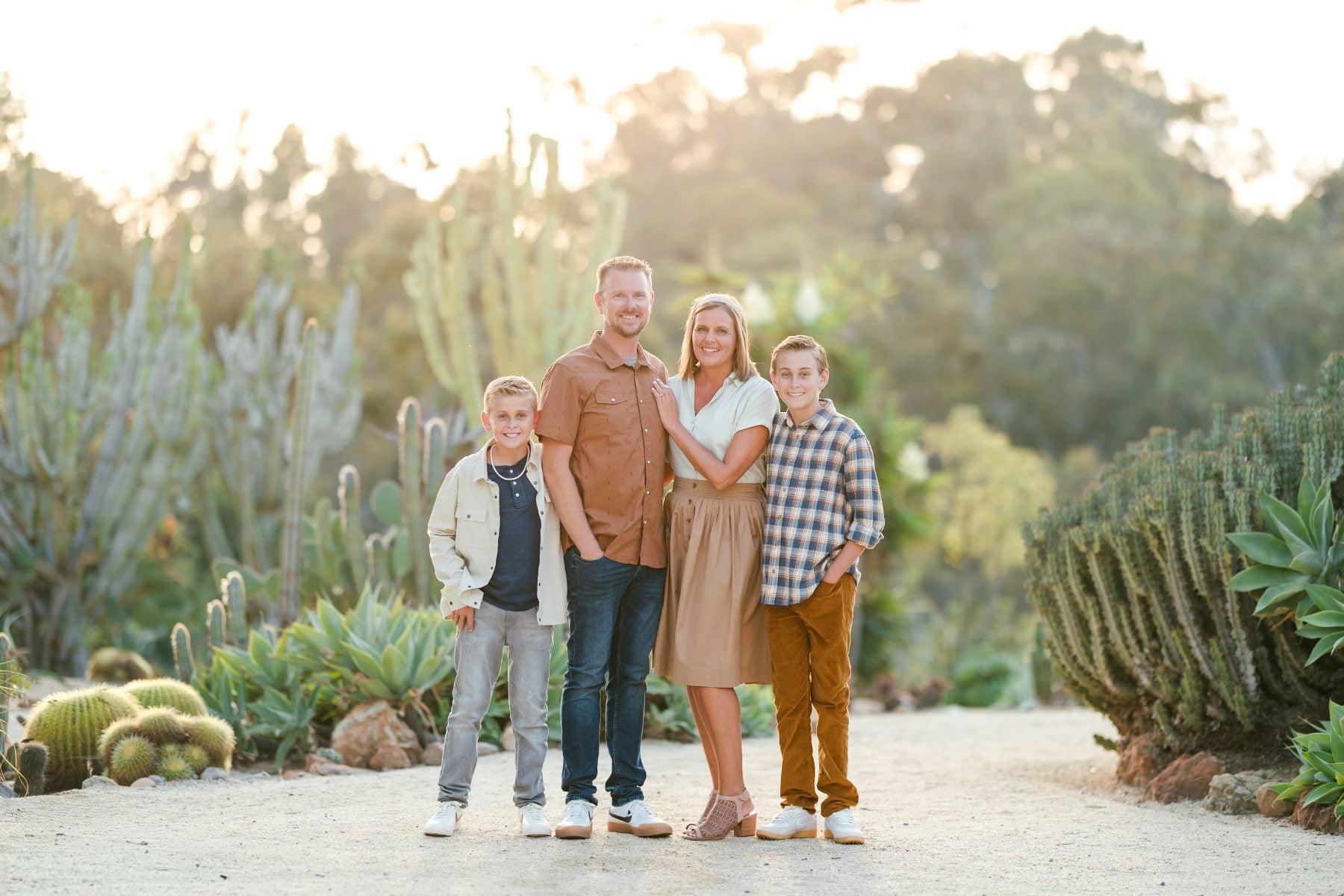Family of four smiles among desert cacti at Iron Mountain Trailhead