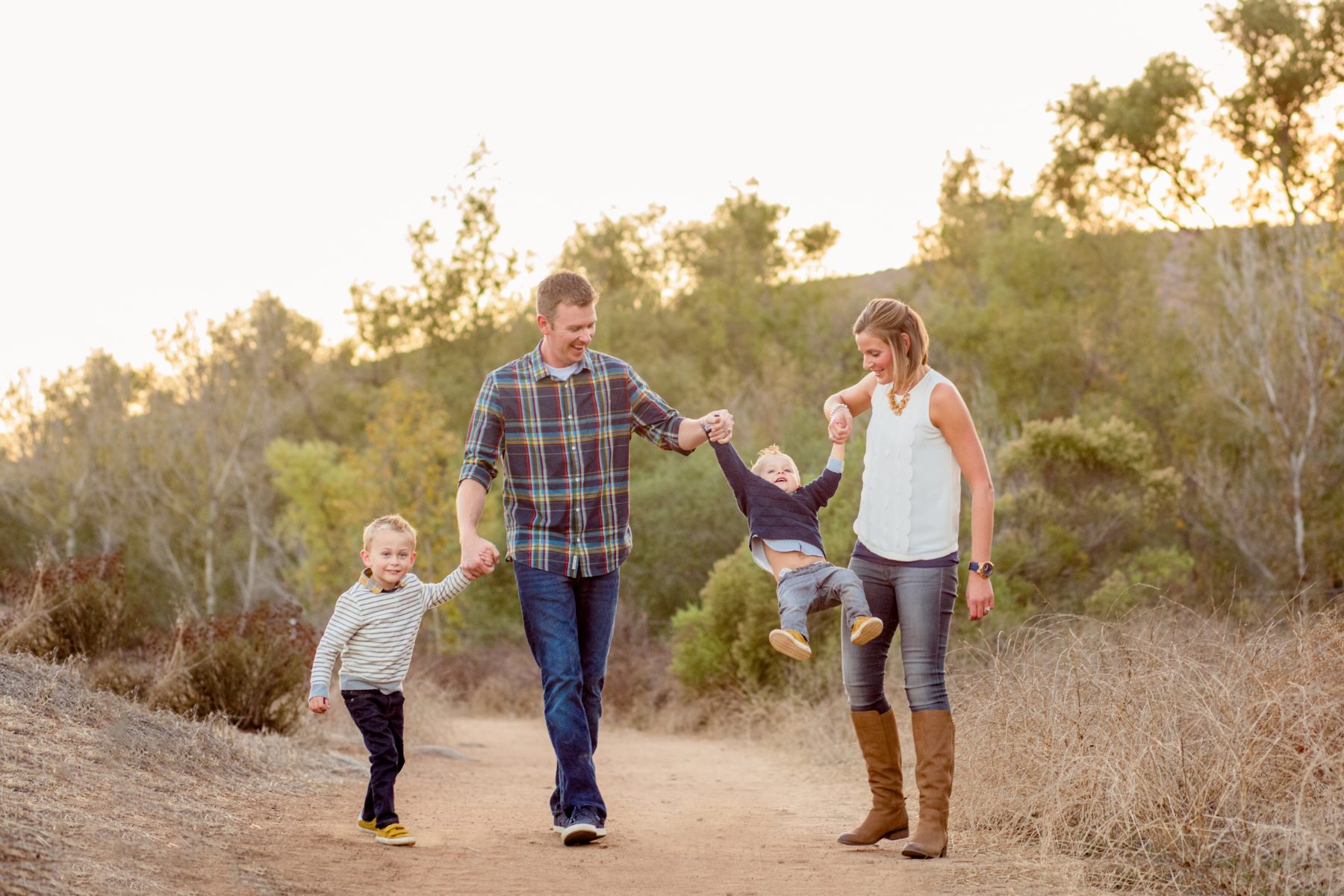 Dad swings toddler son's hand while walking the Iron Mountain Trailhead path