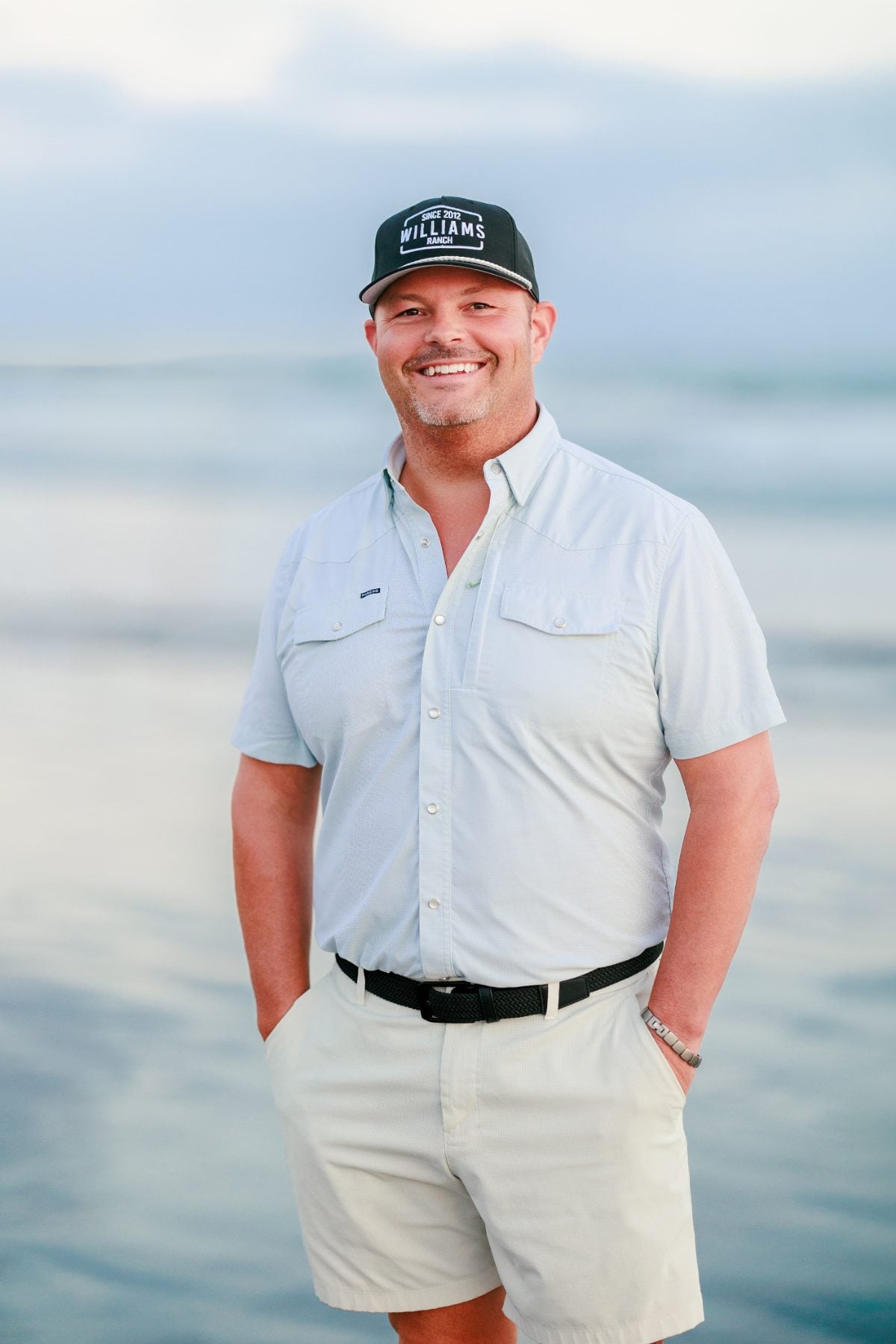 Man in cap and gray shirt poses on Coronado Beach shoreline