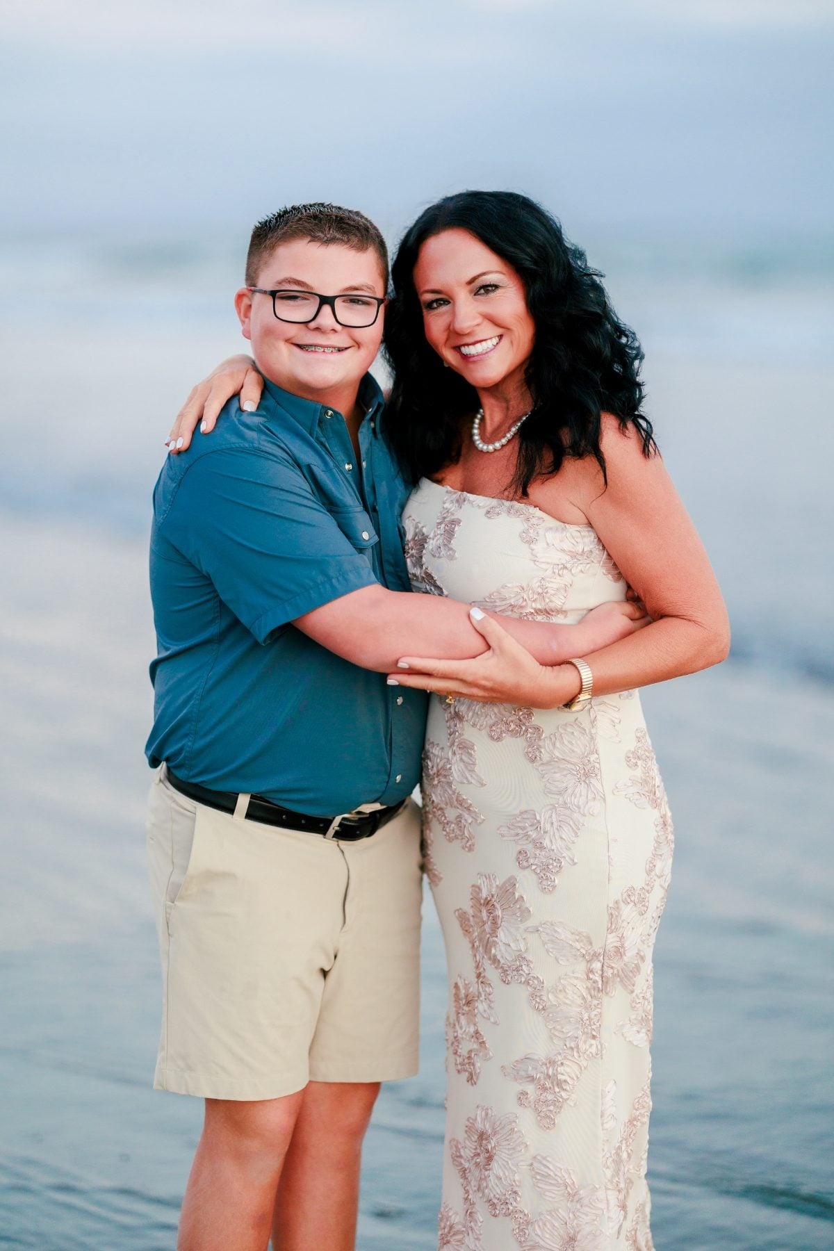 Mother embraces teenage son during beach family photos in Coronado