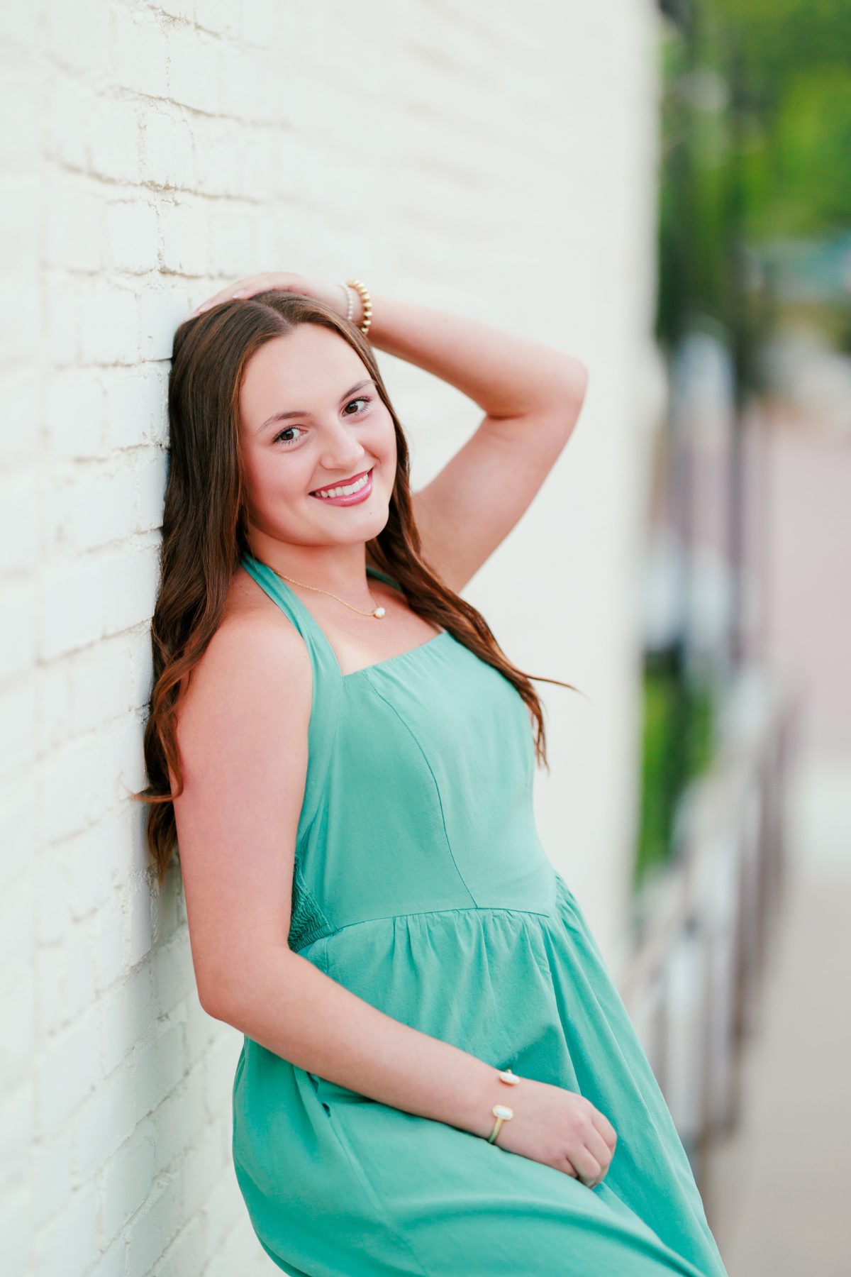 San Diego senior portrait of teenage girl leaning against white brick wall