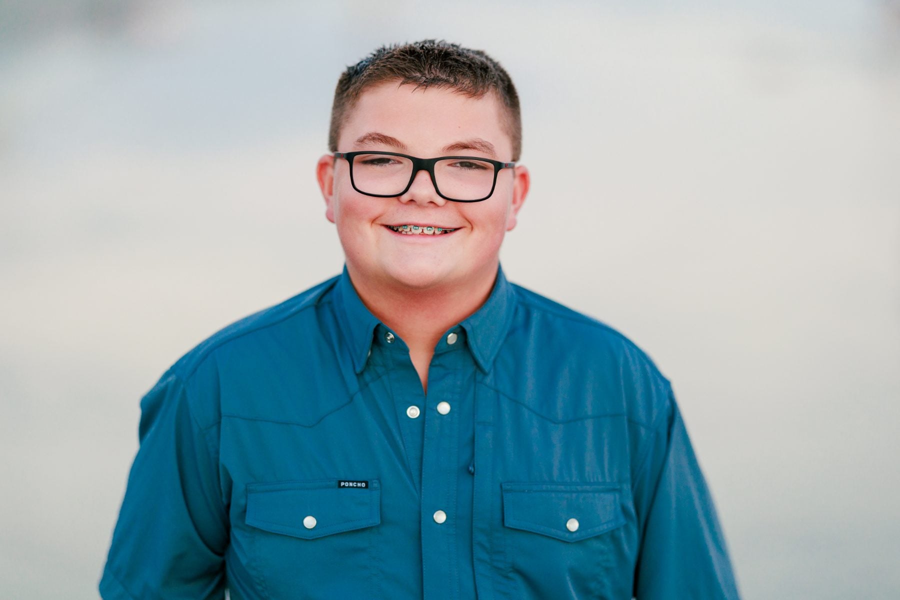 Teen boy in blue shirt smiles for San Diego headshots