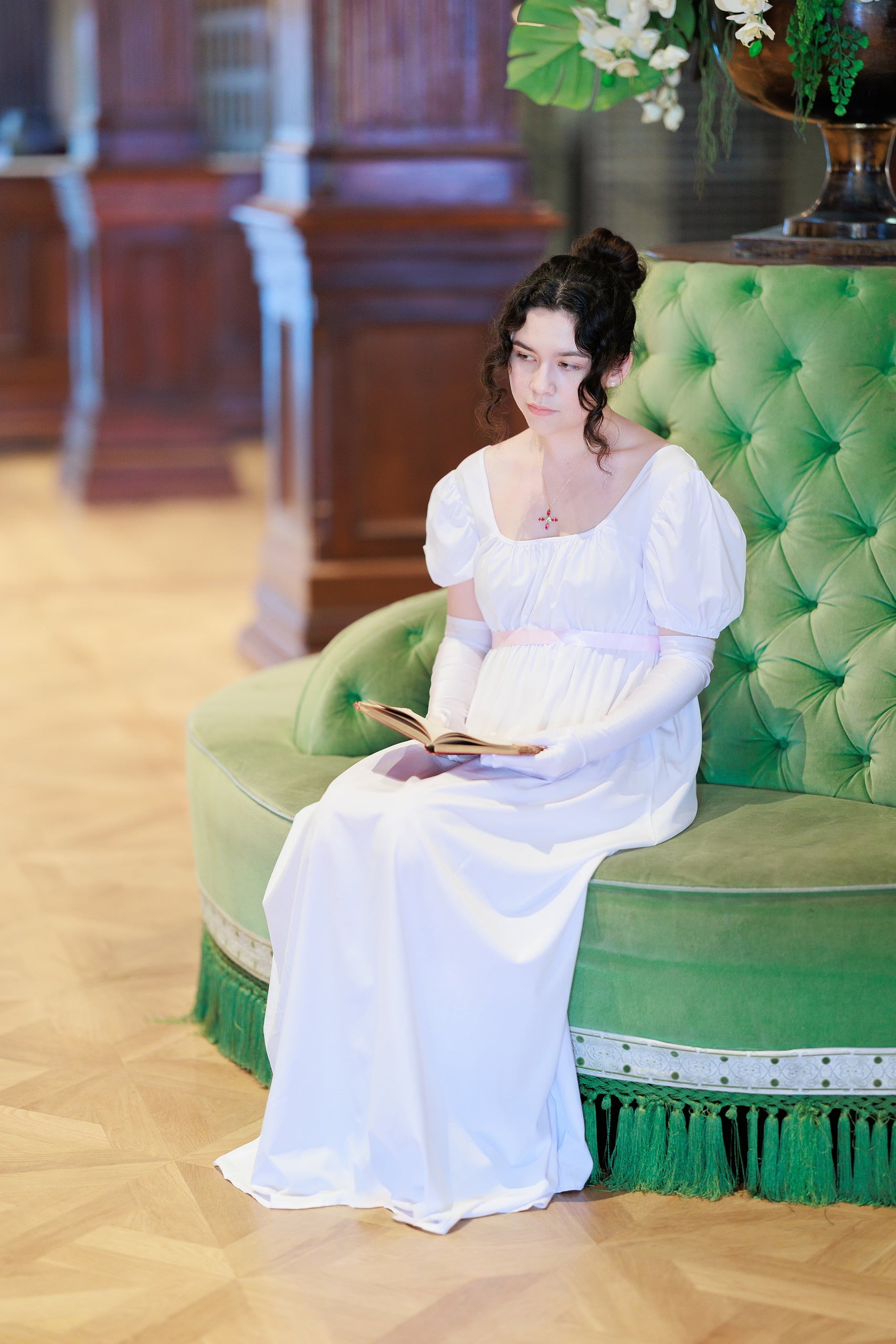Amanda Fagan’s Love, Jane — 07 Woman in white dress on green velvet chair reading book in Hotel del Coronado lobby