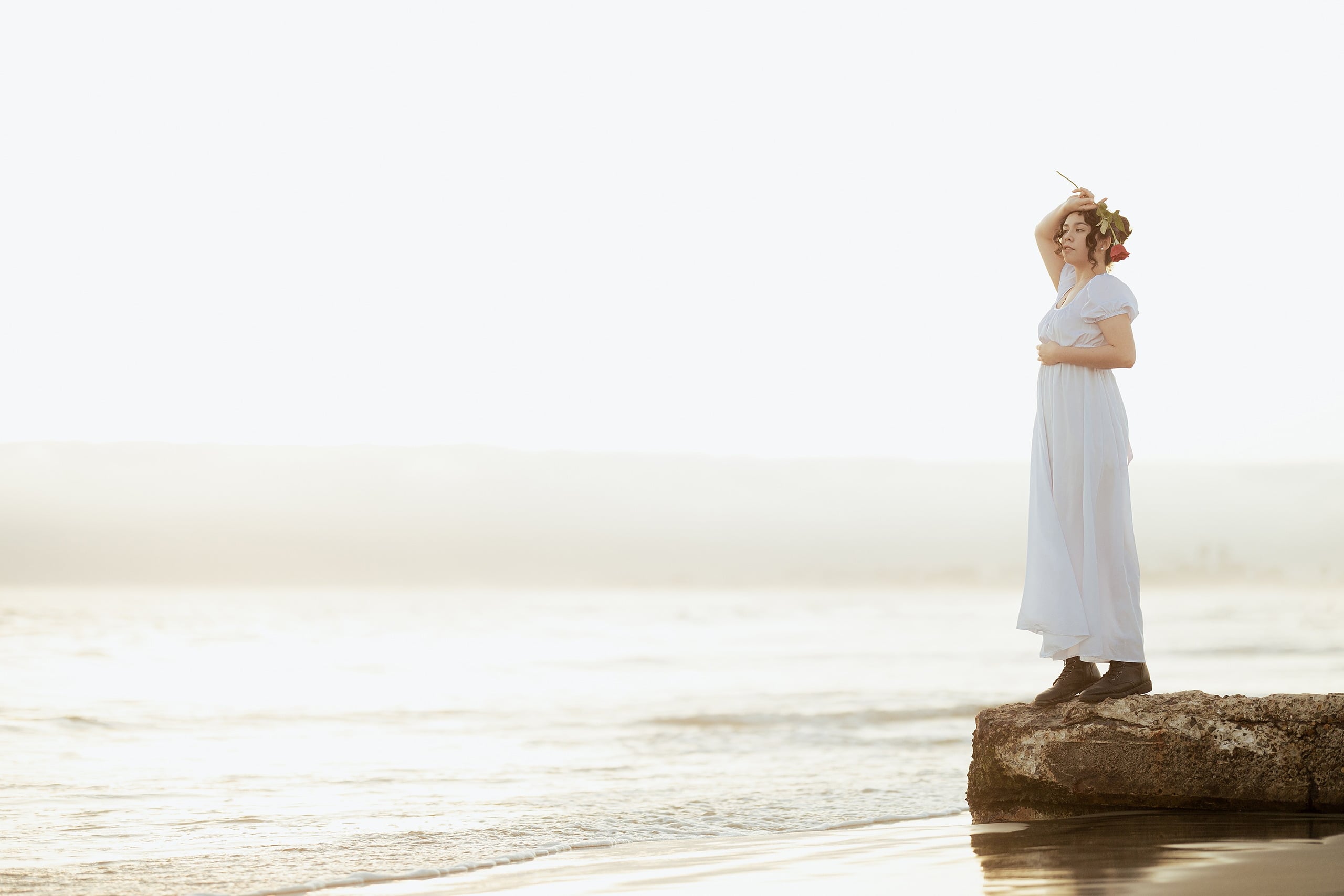 Amanda Fagan’s Love, Jane — 16 Woman in white dress standing on rock in shallow ocean, arms crossed