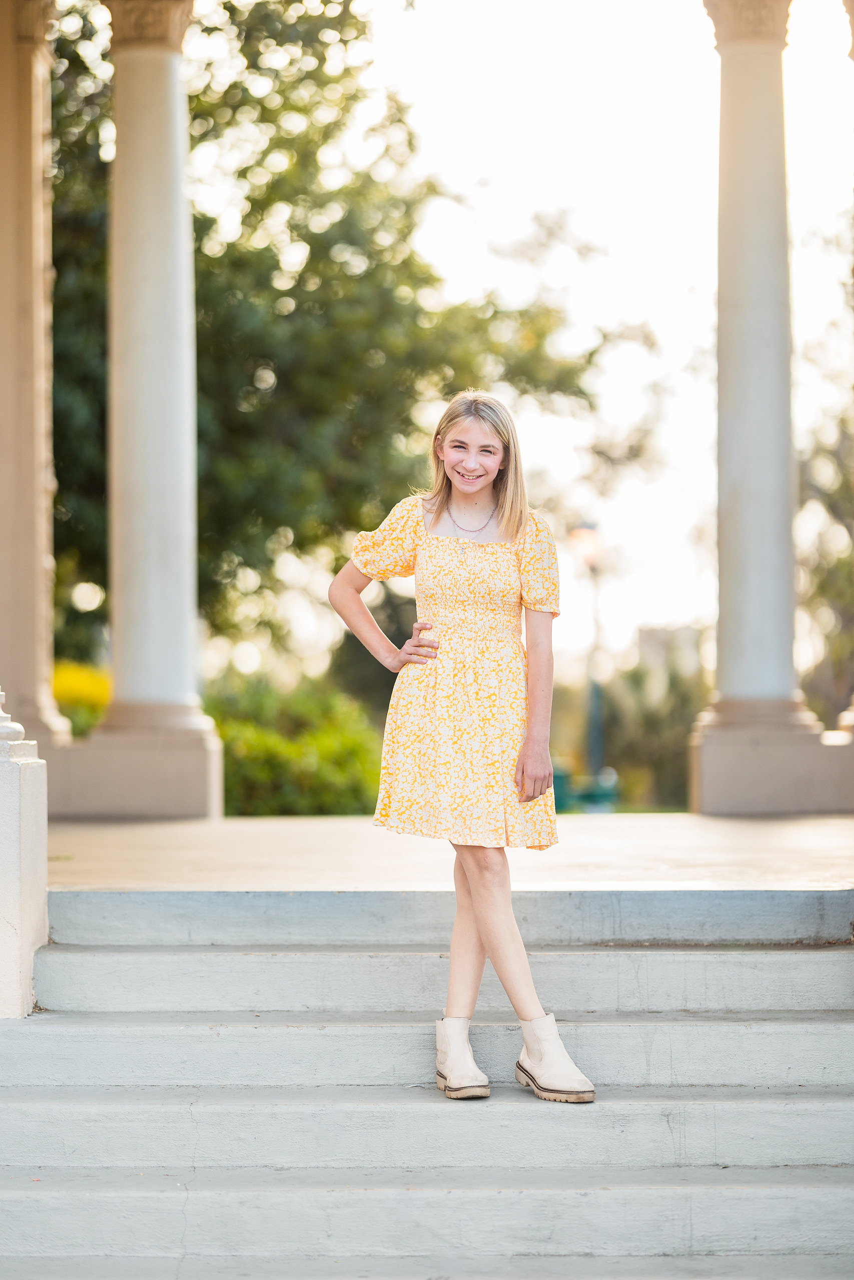 Balboa Park Family Portraits San Diego — 01 Teen girl in yellow dress posing between stone columns at Balboa Park