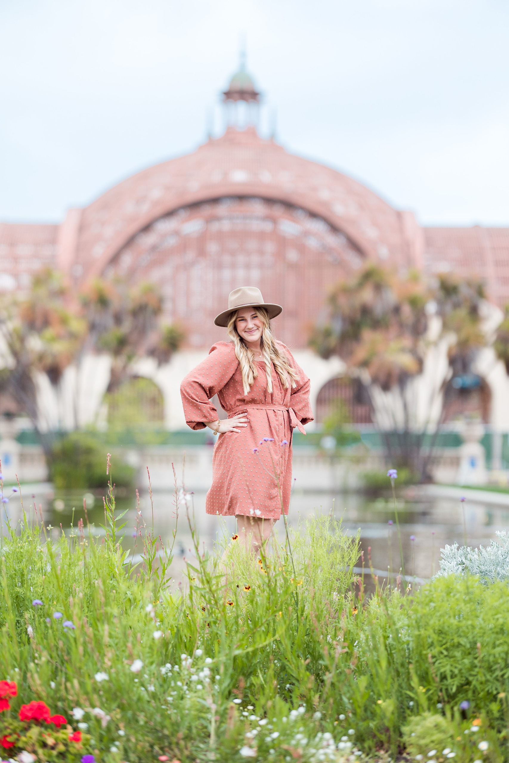 Balboa Park Senior Photography Session — 12 Senior in light blue dress leaning against stone column, arches in background