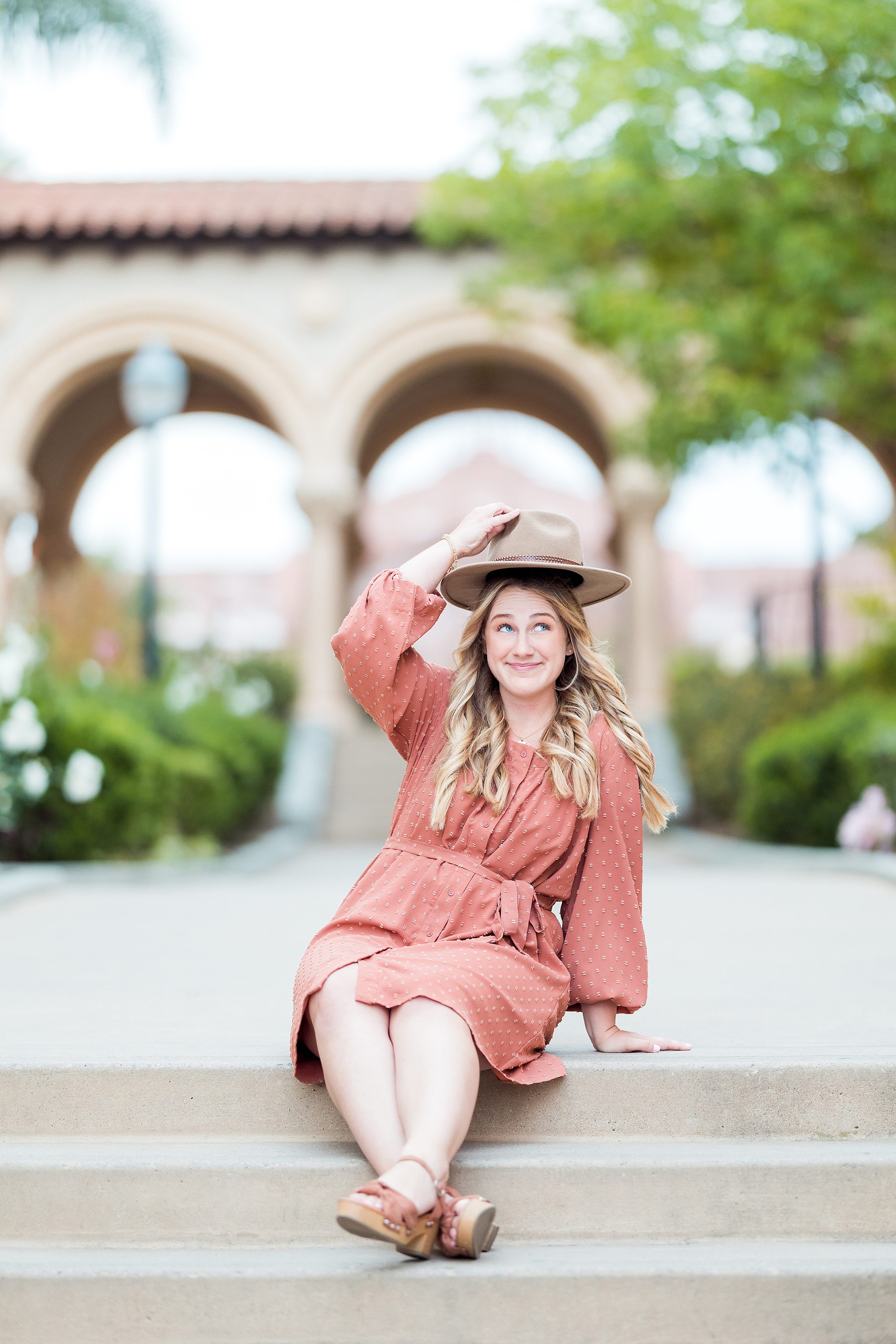 Balboa Park Senior Photography Session — 13 Senior in light blue dress walking through elegant arched hallway at Hotel del Coronado