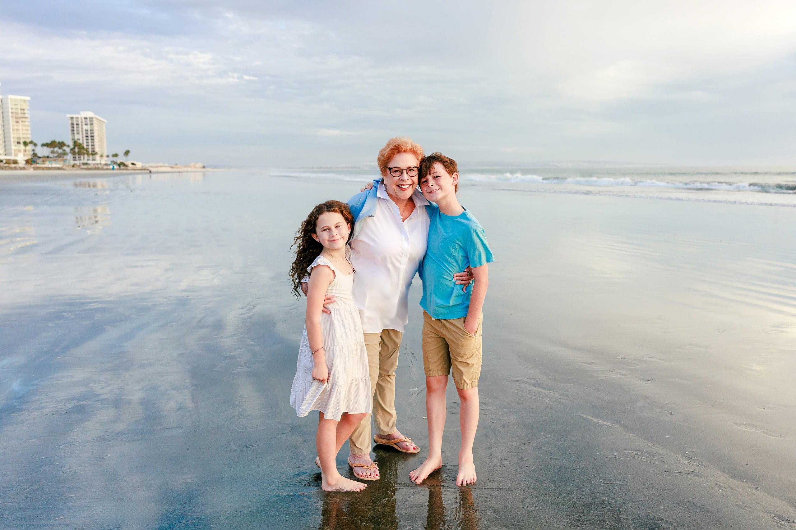 Behind the Scenes of Grammy Judy’s 80th Birthday Session: An Interview with Wendy — 05 Grammy Judy and family gather on beach with Hotel del Coronado visible in distance
