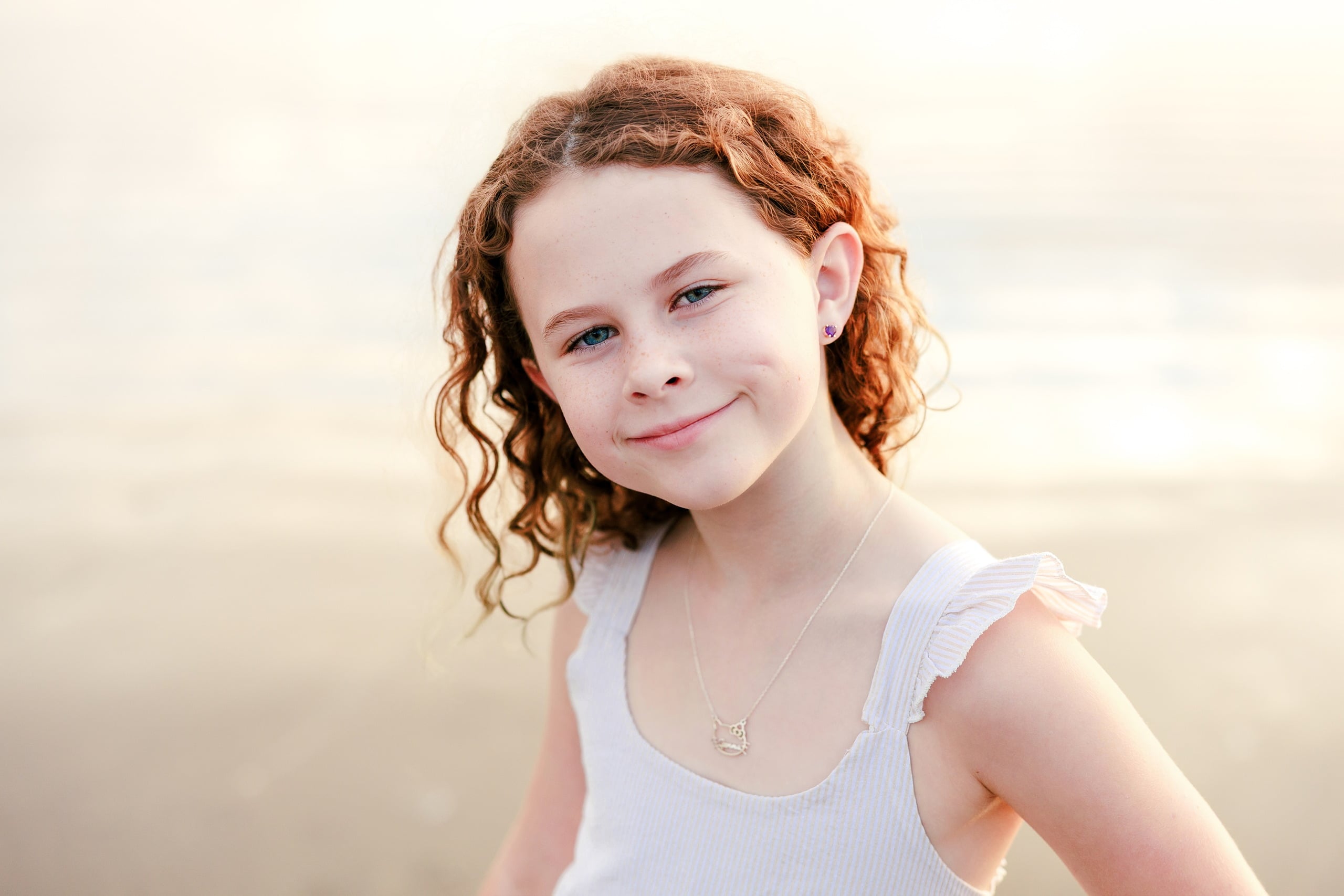 Behind the Scenes of Grammy Judy’s 80th Birthday Session: An Interview with Wendy — 10 Close-up of girl with curly hair in white sleeveless top on beach at soft golden hour