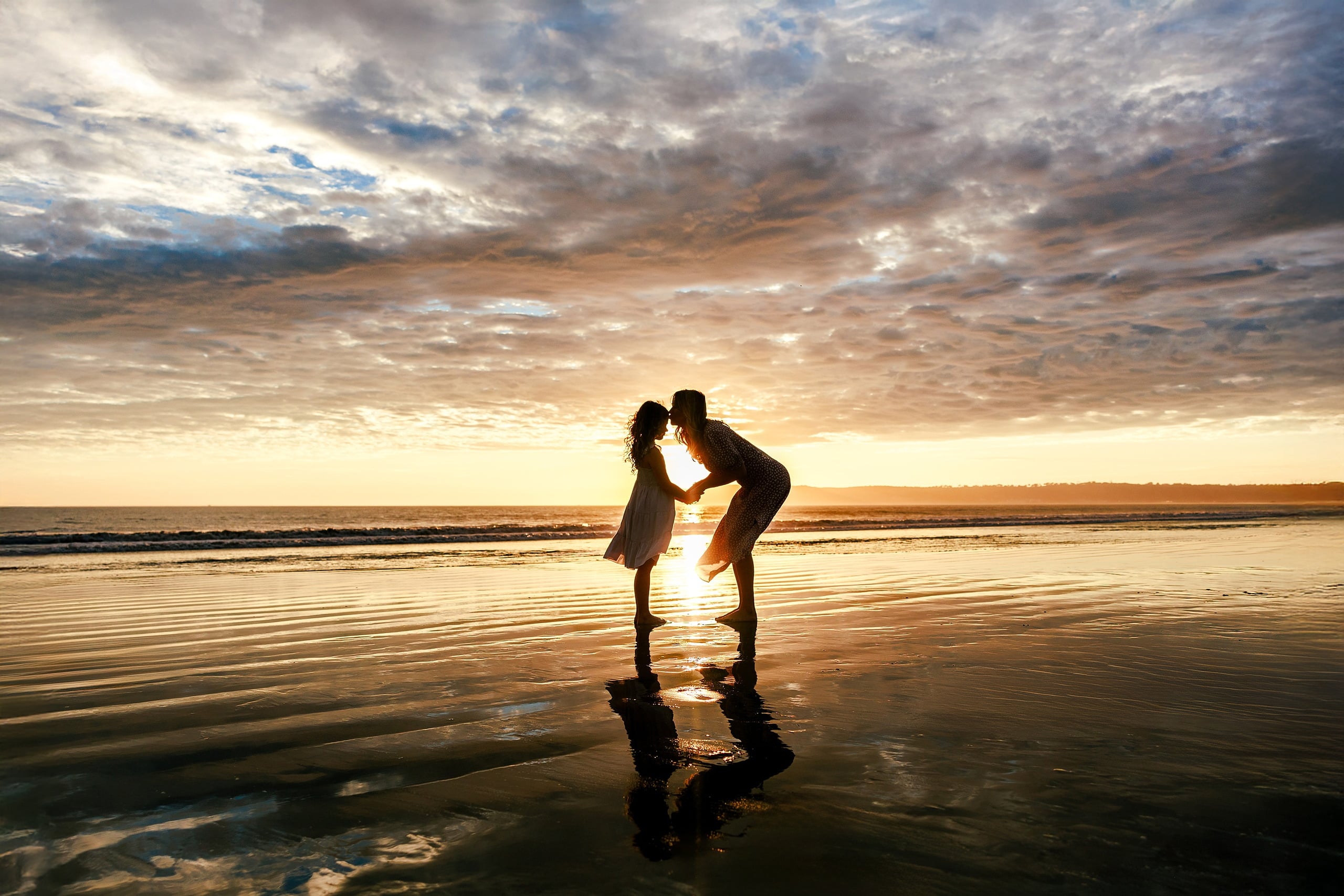 Behind the Scenes of Grammy Judy’s 80th Birthday Session: An Interview with Wendy — 16 Man and girl share a close moment on beach, silhouetted against orange and gold sunset