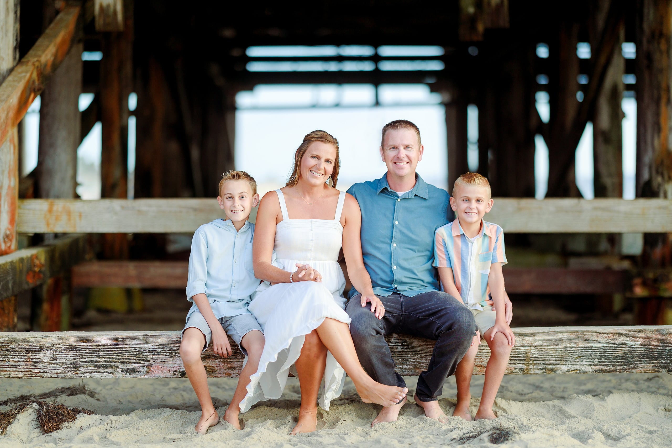 Butlers on the Beach — 04 Woman in white dress sitting on sand with man and two boys under Crystal Pier