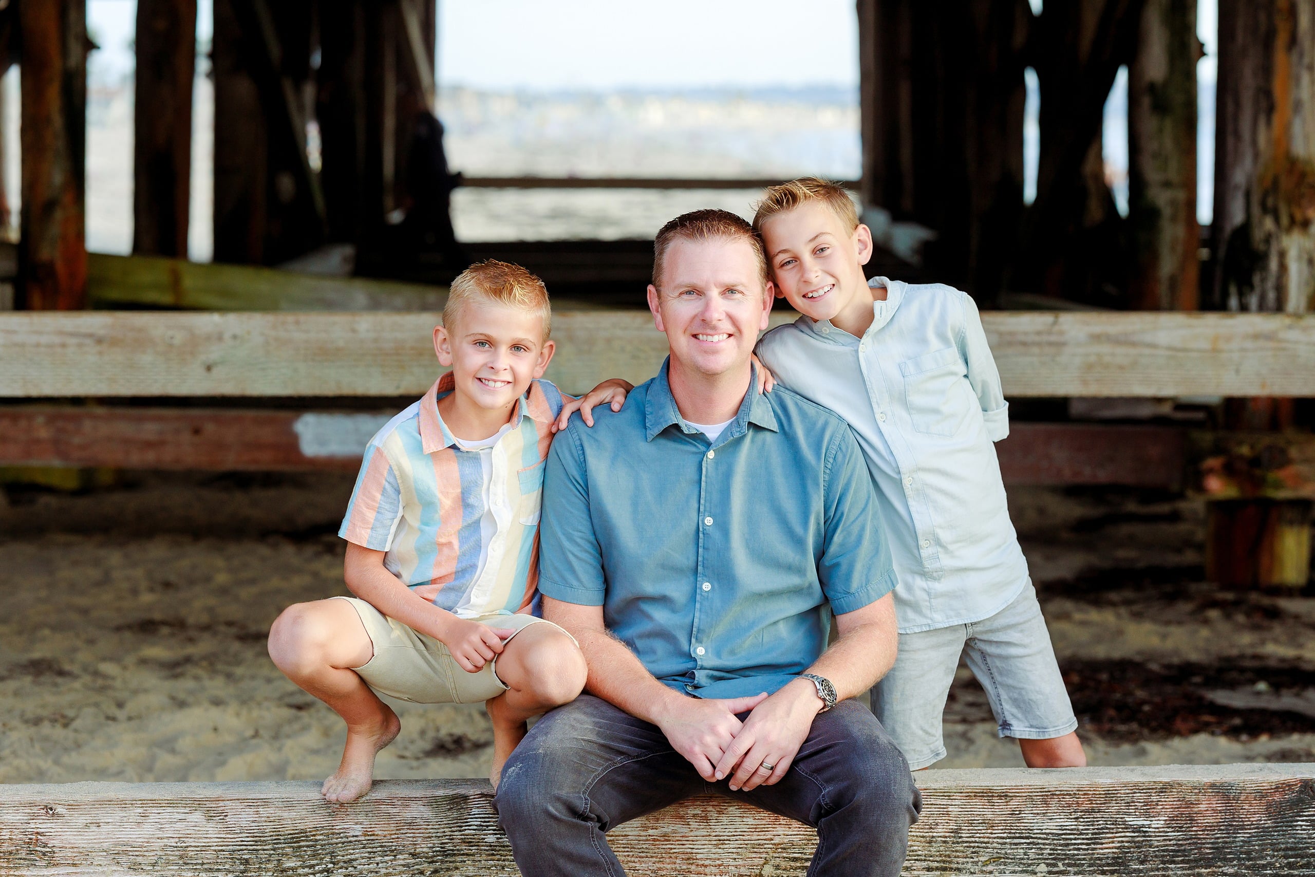 Butlers on the Beach — 06 Man in blue shirt crouching together with two boys on weathered Crystal Pier