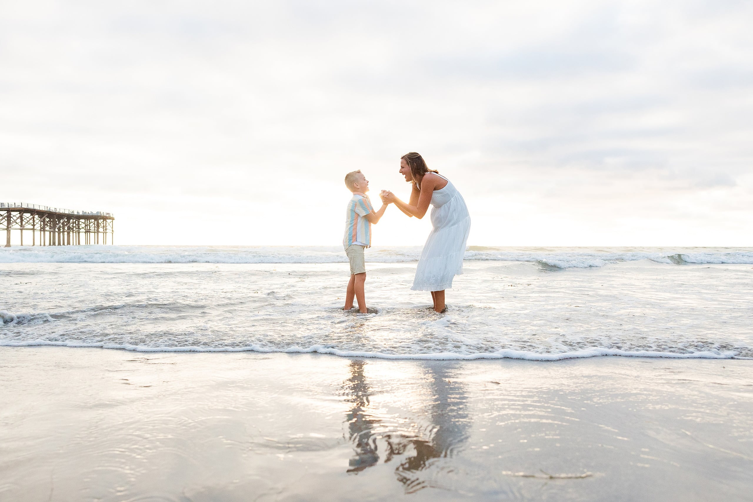 Butlers on the Beach — 13 Woman in white dress standing with boy at water's edge near Crystal Pier