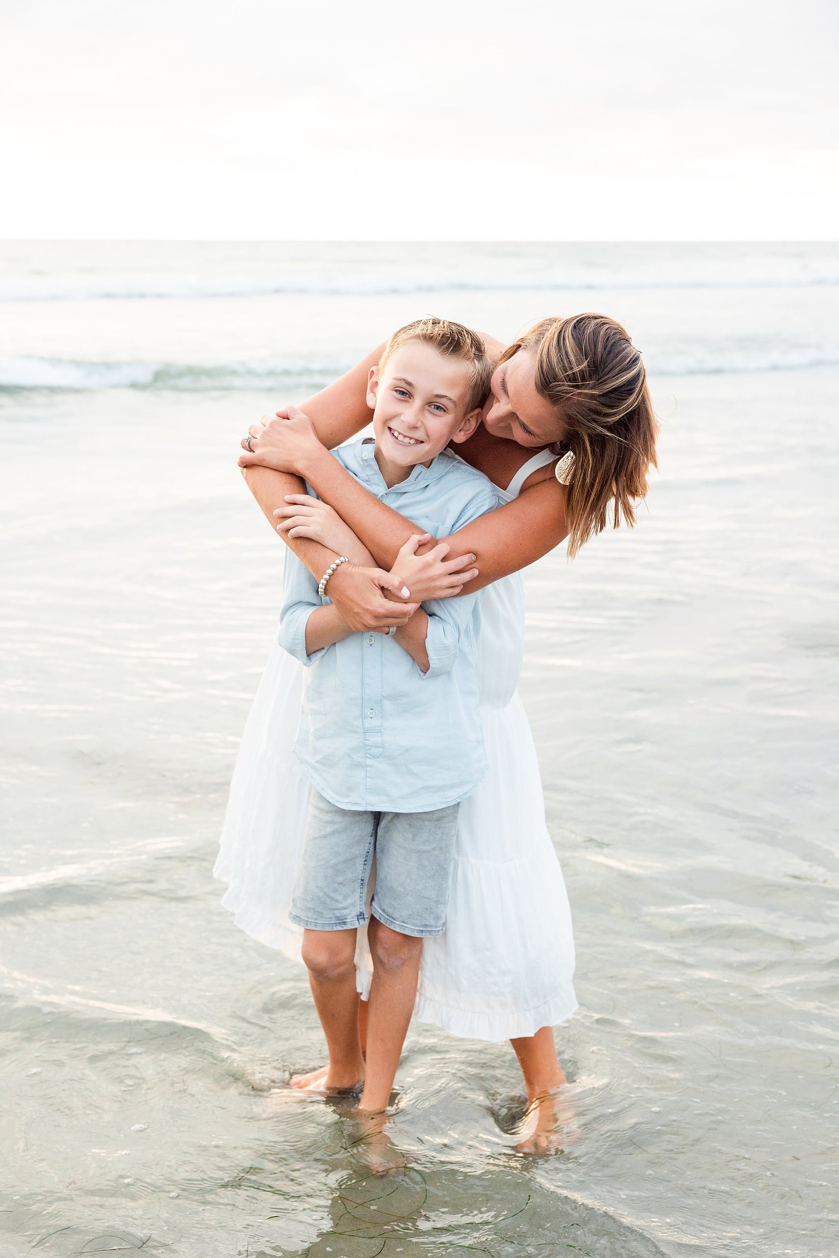Butlers on the Beach — 14 Woman in white dress holding boy and kissing his head at the beach