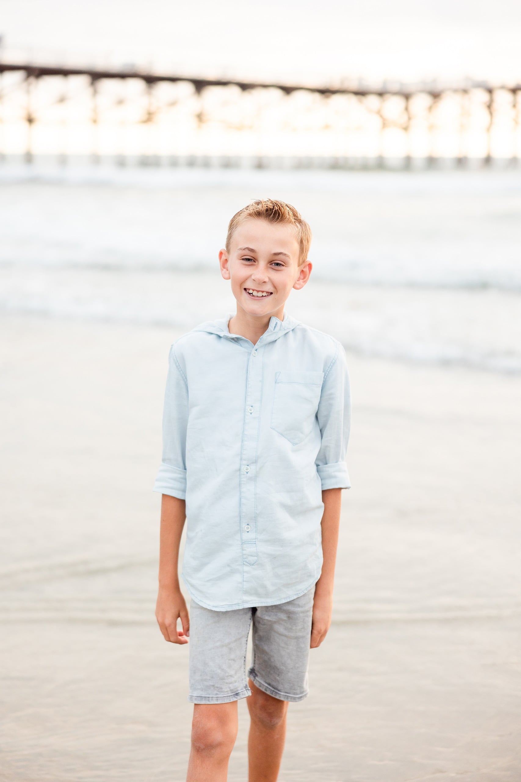 Butlers on the Beach — 17 Boy in light blue button-up shirt smiling on sand at Crystal Pier