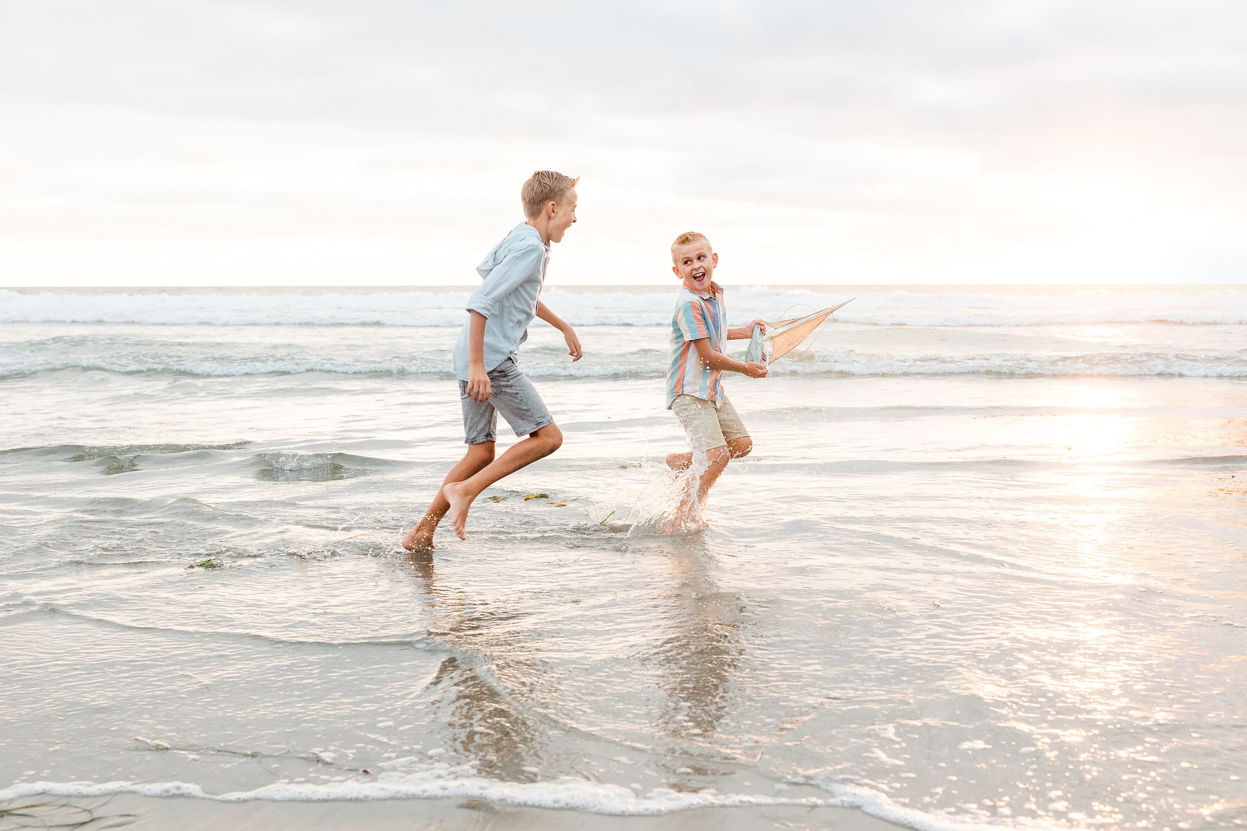 Butlers on the Beach — 22 Two boys running side-by-side through shallow water at sunset