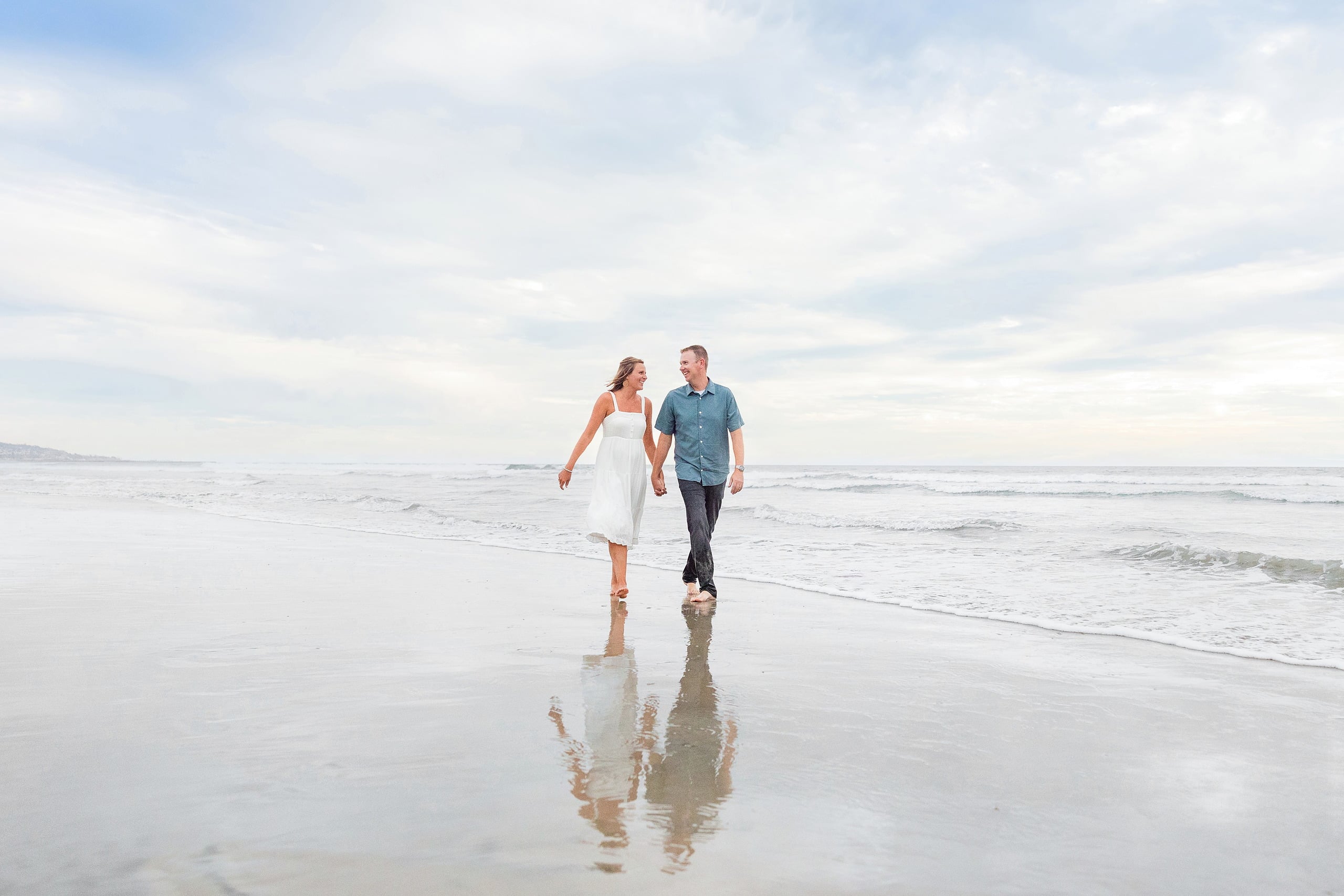 Butlers on the Beach — 27 Woman and man walking together in shallow water with Crystal Pier in background