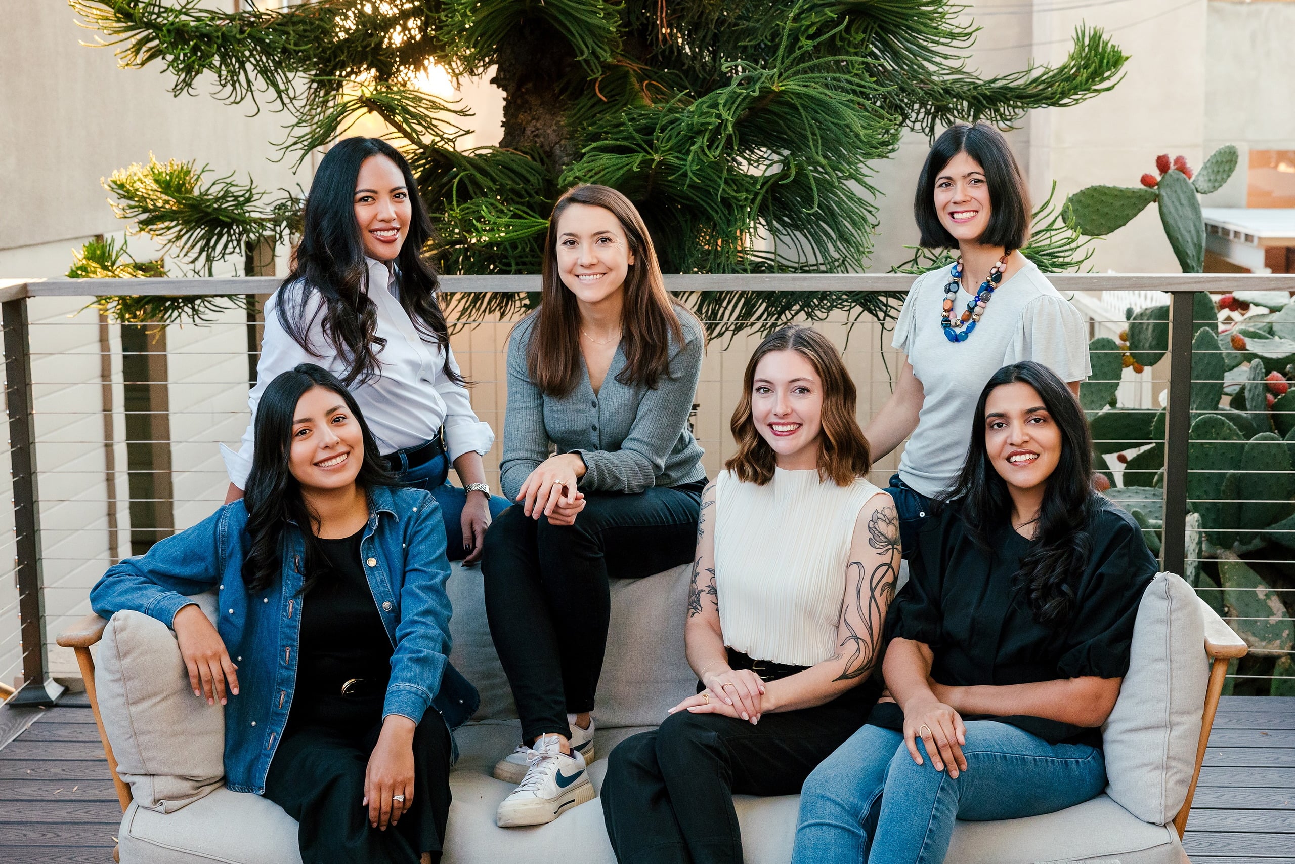 Capturing San Diego Spirit: Intention 2 Impact’s Team Retreat at Windansea — 01 Six women posed together on La Jolla Airbnb deck with potted plants