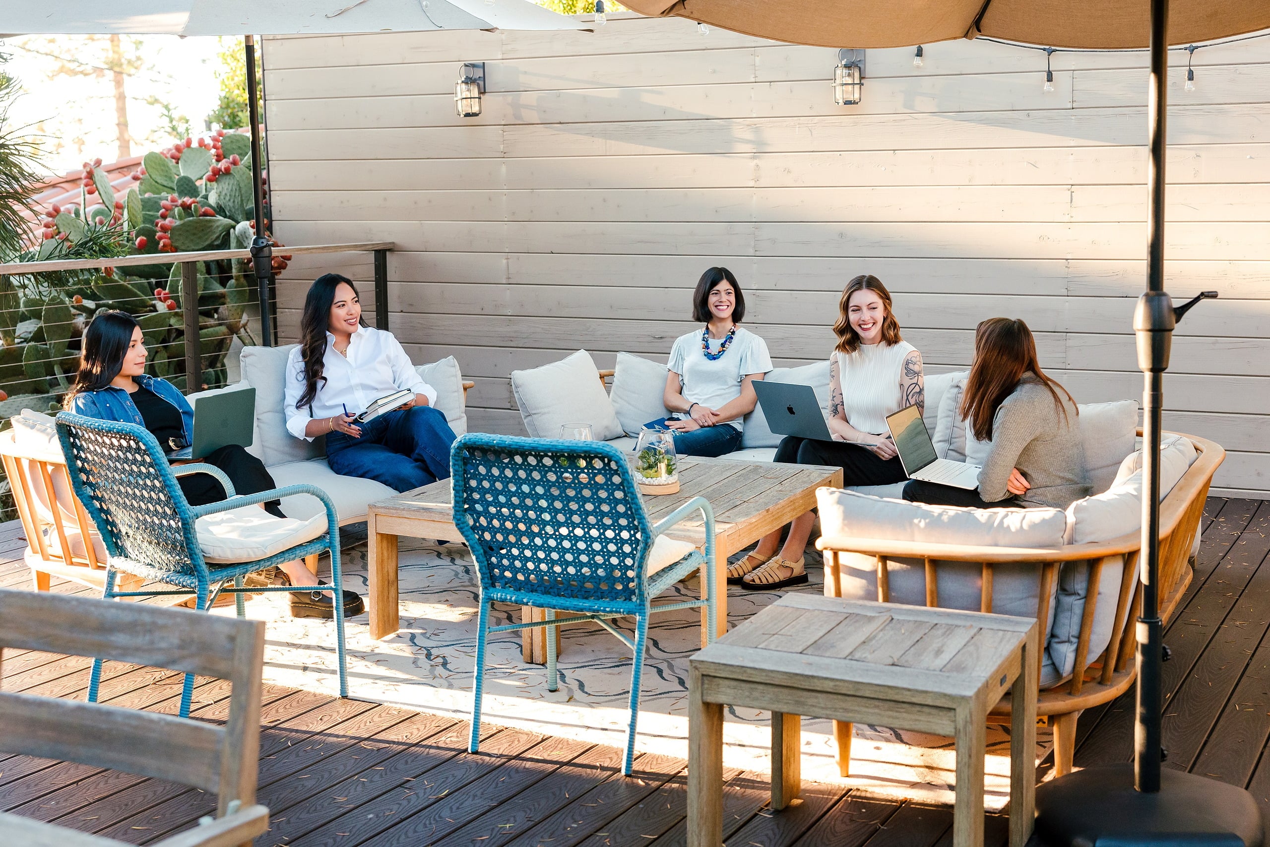 Capturing San Diego Spirit: Intention 2 Impact’s Team Retreat at Windansea — 20 Intention 2 Impact team seated together on La Jolla deck in sunshine