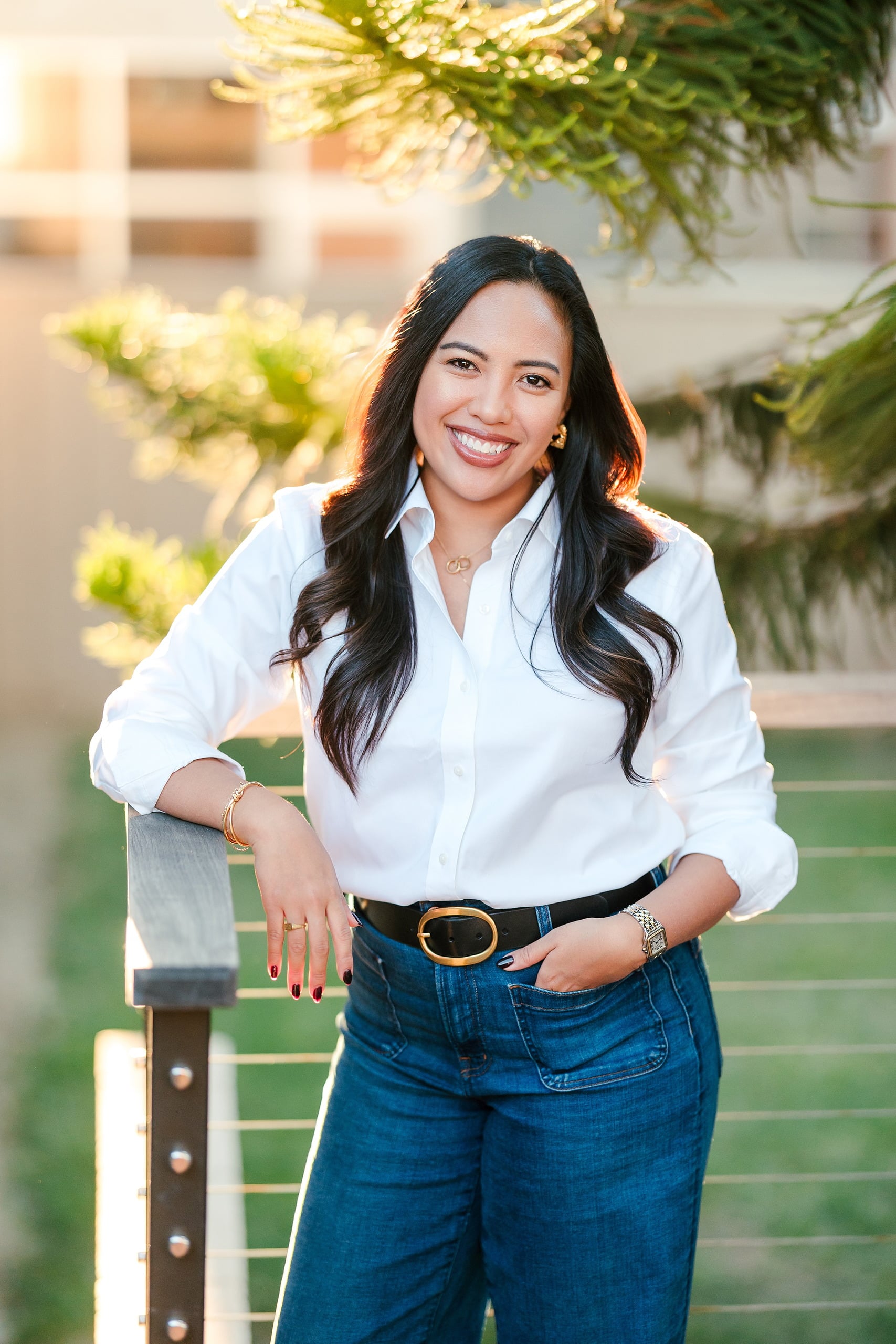 Capturing San Diego Spirit: Intention 2 Impact’s Team Retreat at Windansea — 29 Woman in white button-up with gold belt on deck at golden hour