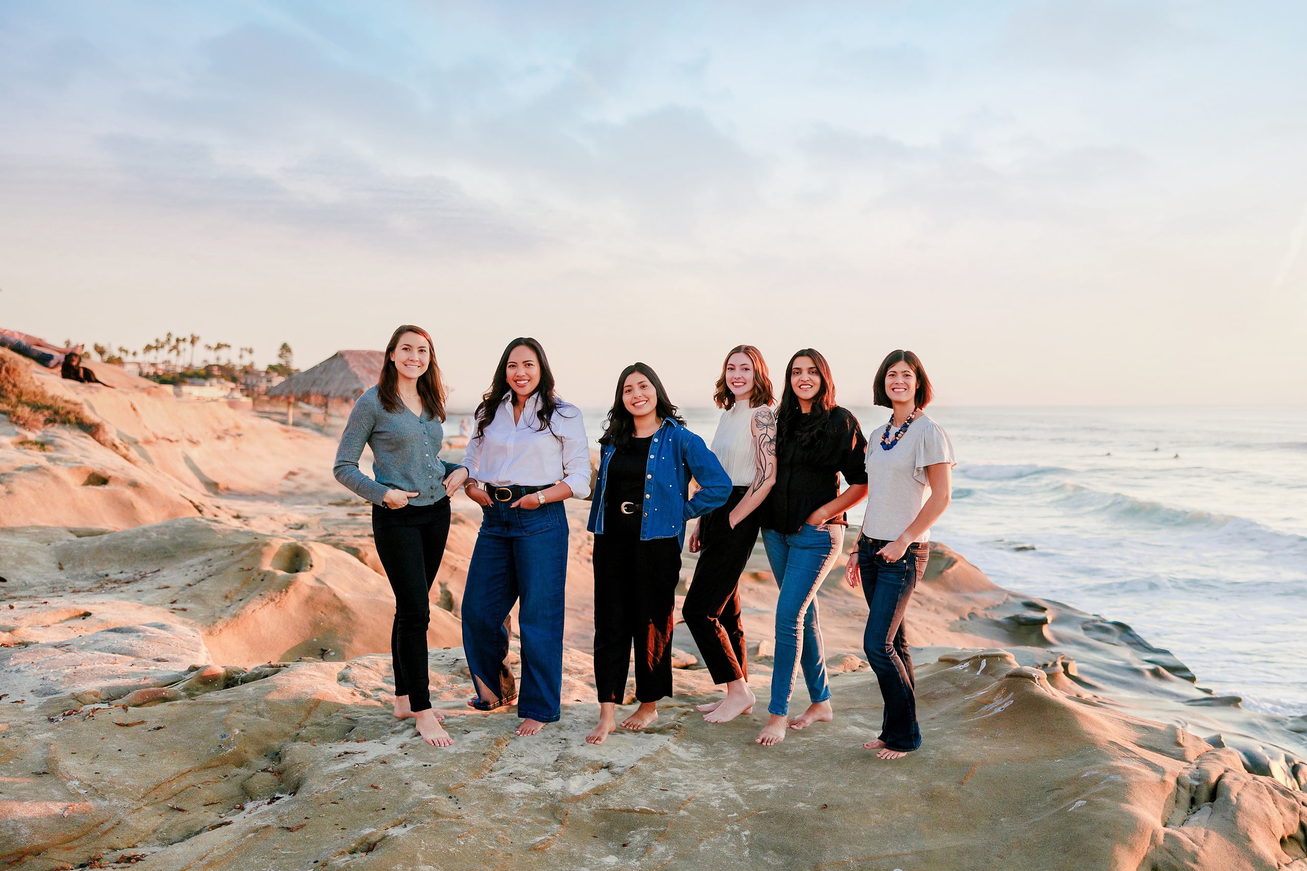 Capturing San Diego Spirit: Intention 2 Impact’s Team Retreat at Windansea — 30 Six women standing barefoot on Windansea beach with rocks and waves