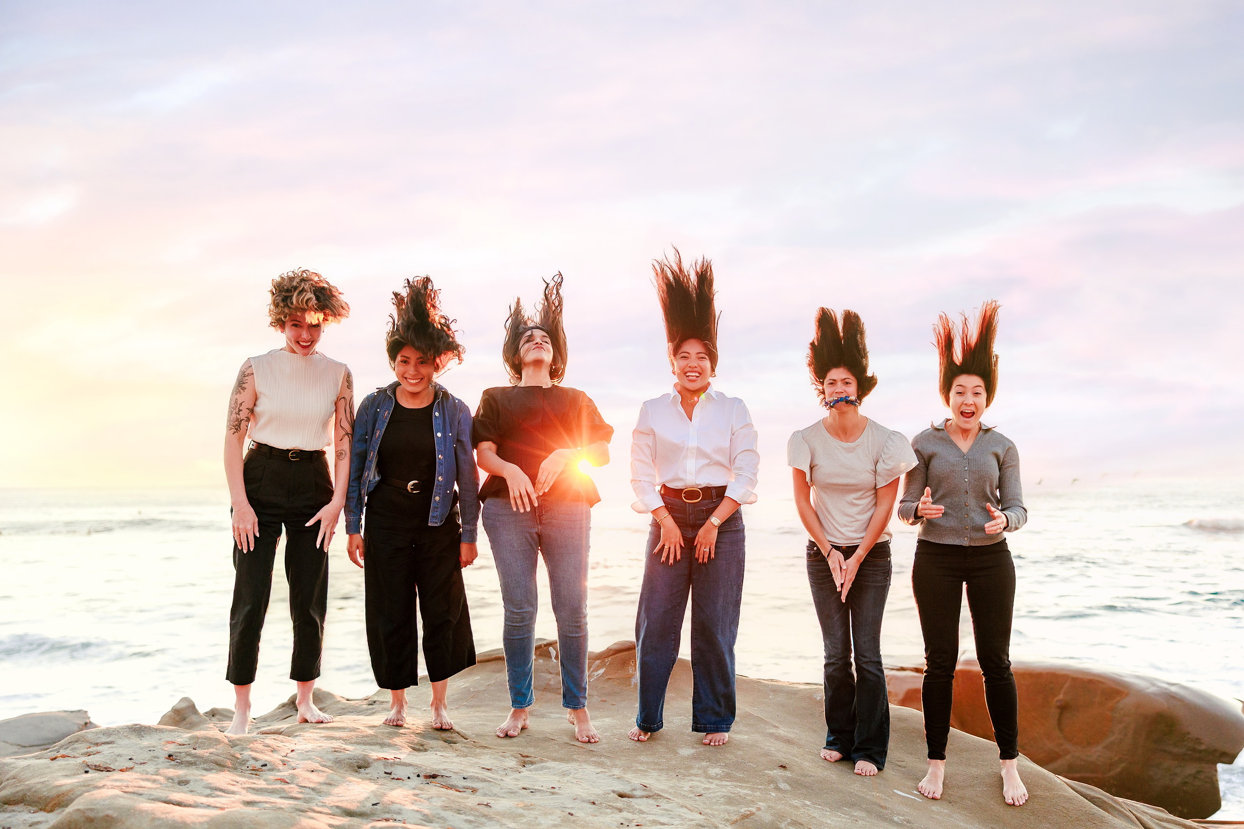 Capturing San Diego Spirit: Intention 2 Impact’s Team Retreat at Windansea — 31 Team of six women jumping with hands raised in silhouette at sunset