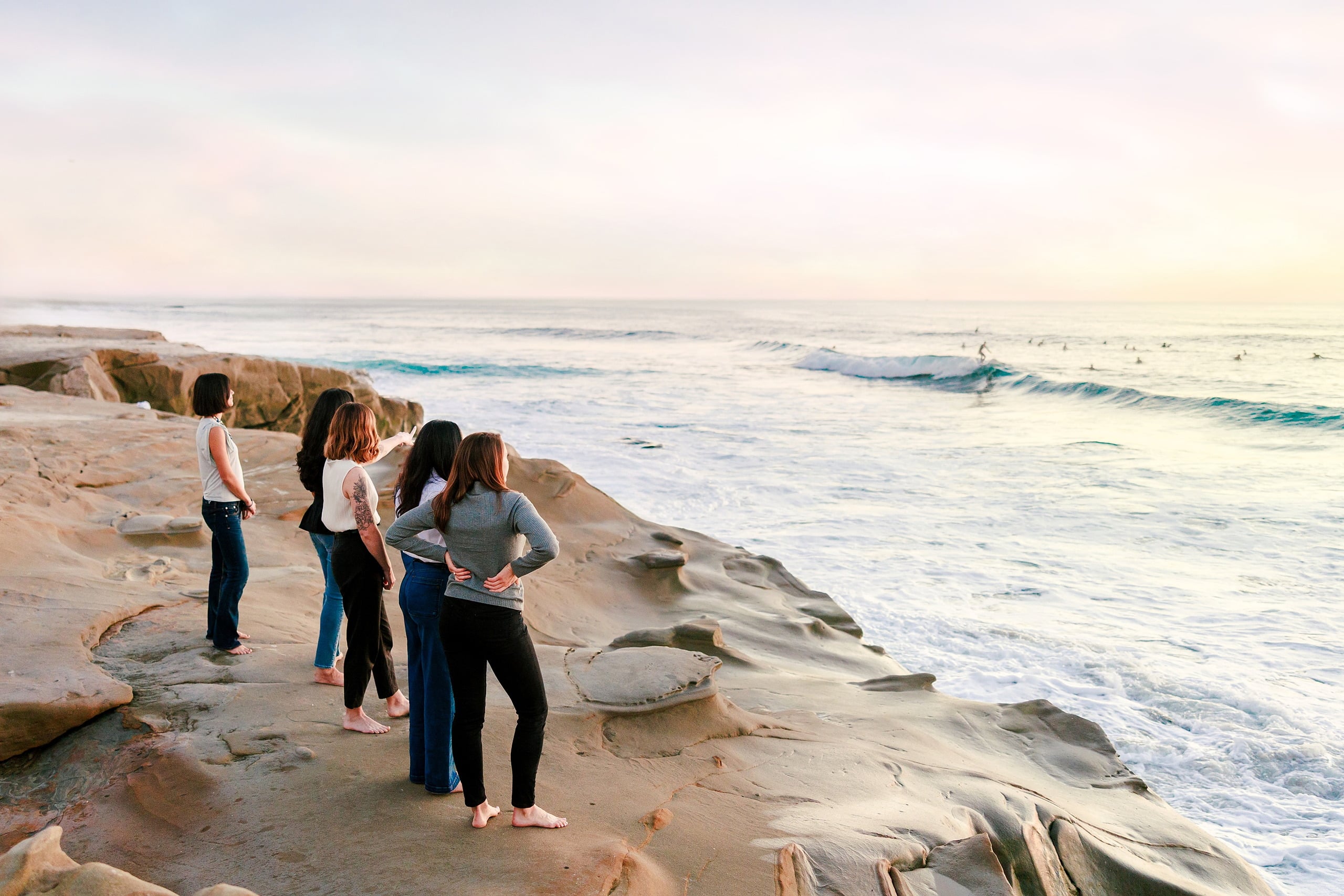 Capturing San Diego Spirit: Intention 2 Impact’s Team Retreat at Windansea — 34 Four women walking through shallow water at Windansea rocky shoreline
