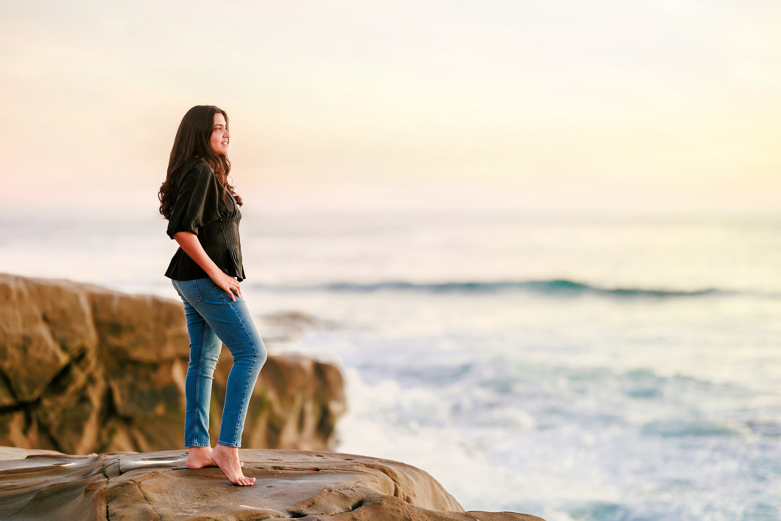 Capturing San Diego Spirit: Intention 2 Impact’s Team Retreat at Windansea — 40 Woman in white button-up standing barefoot on rock at Windansea sunset