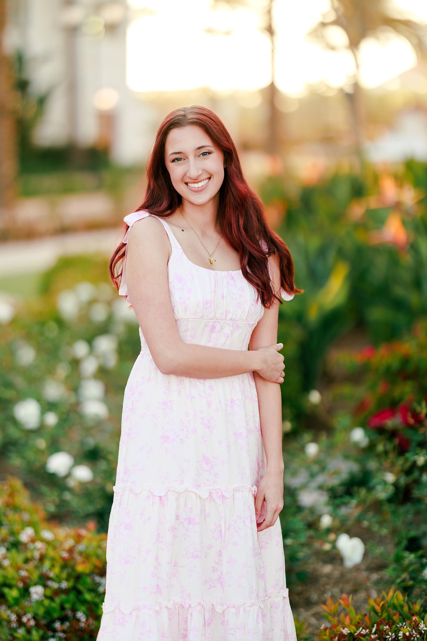 Coronado Beach Memories with the Sanchez Family — 05 Young woman in white and pink tiered dress standing among flowers at Hotel del Coronado
