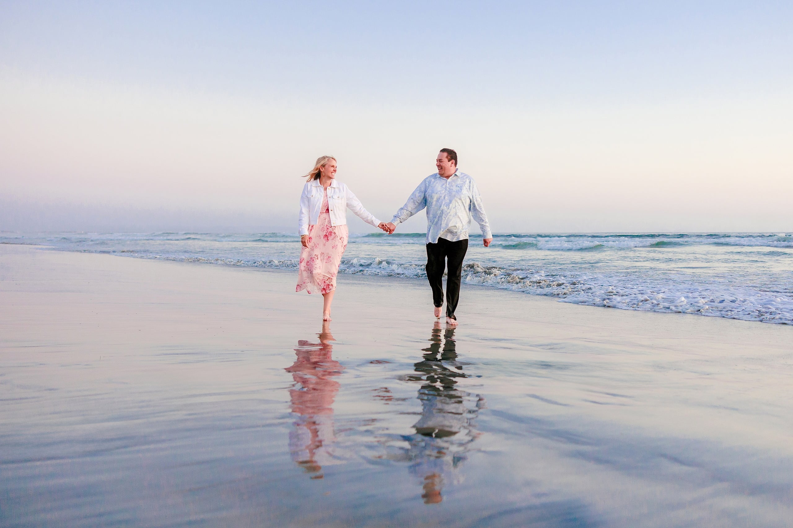 Coronado Beach Memories with the Sanchez Family — 27 Woman and man holding hands running on wet sand at Coronado Beach at sunset