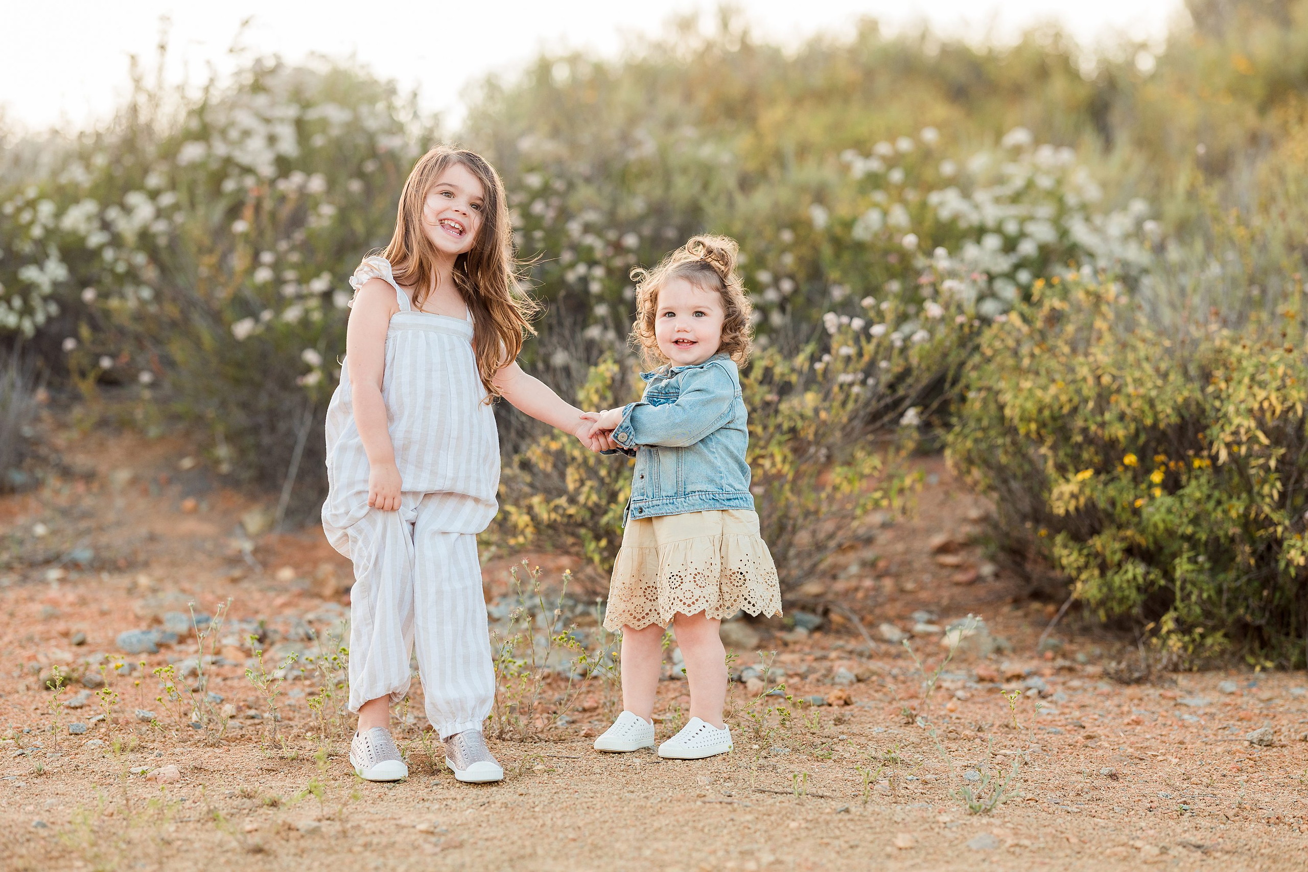 Dictionary Hill Nature Trails Family Photography in San Diego — 08 Older child and toddler walking together on a flowering path at Dictionary Hill