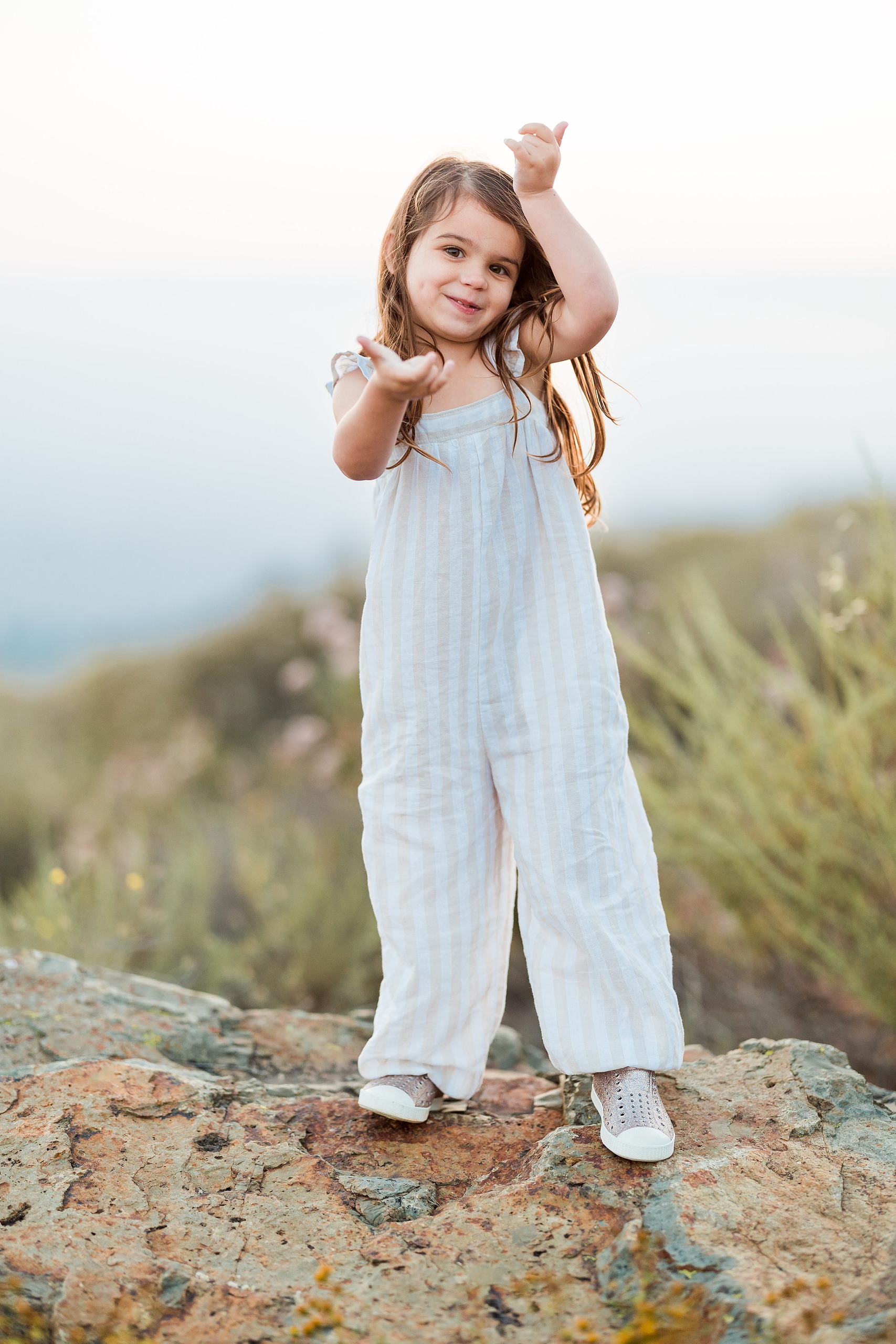 Dictionary Hill Nature Trails Family Photography in San Diego — 24 Child on rock making playful hand gestures at Dictionary Hill